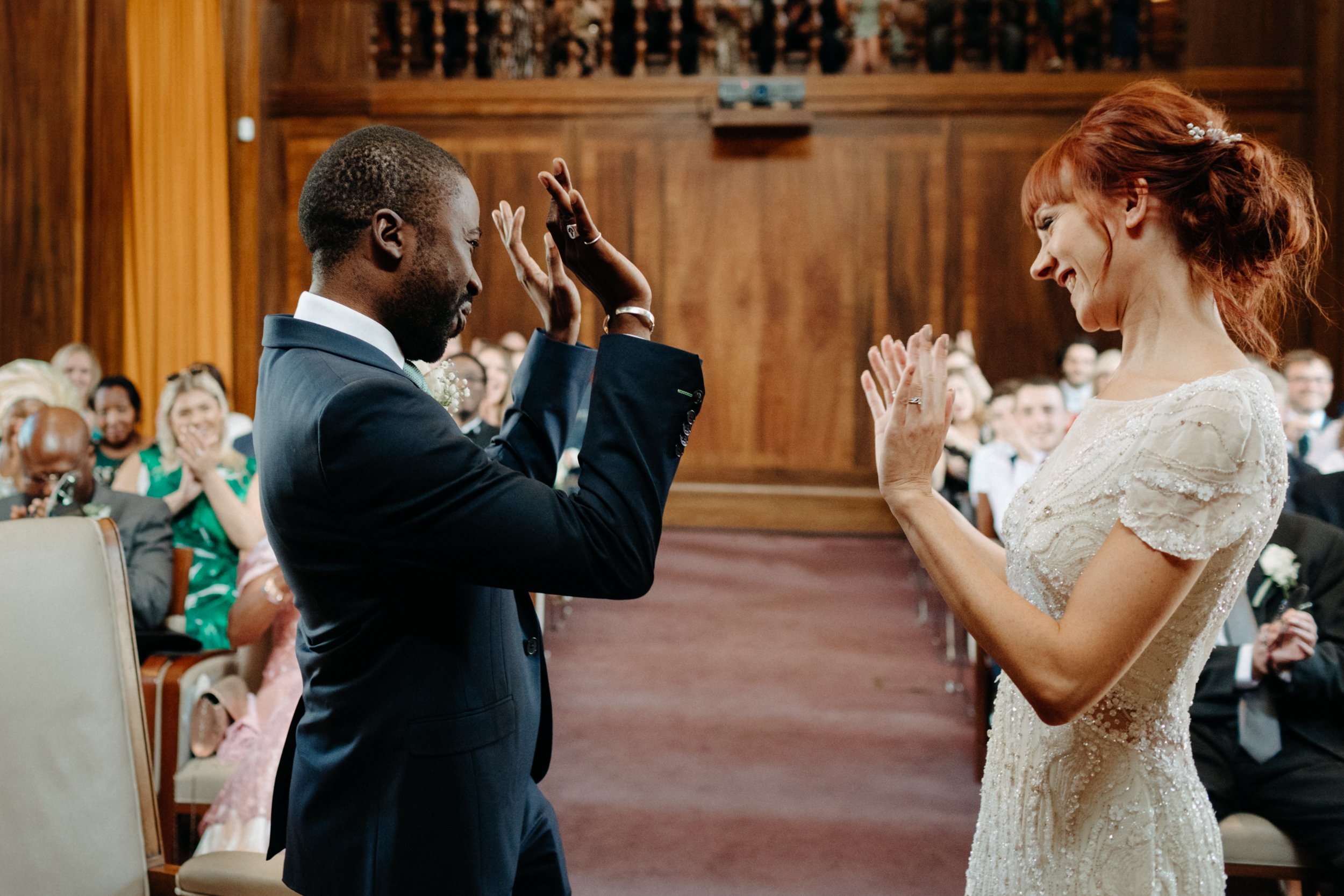  A bride and groom celebrate by throwing their hands in the air after getting married in the council chamber in Stoke Newington Town Hall. 