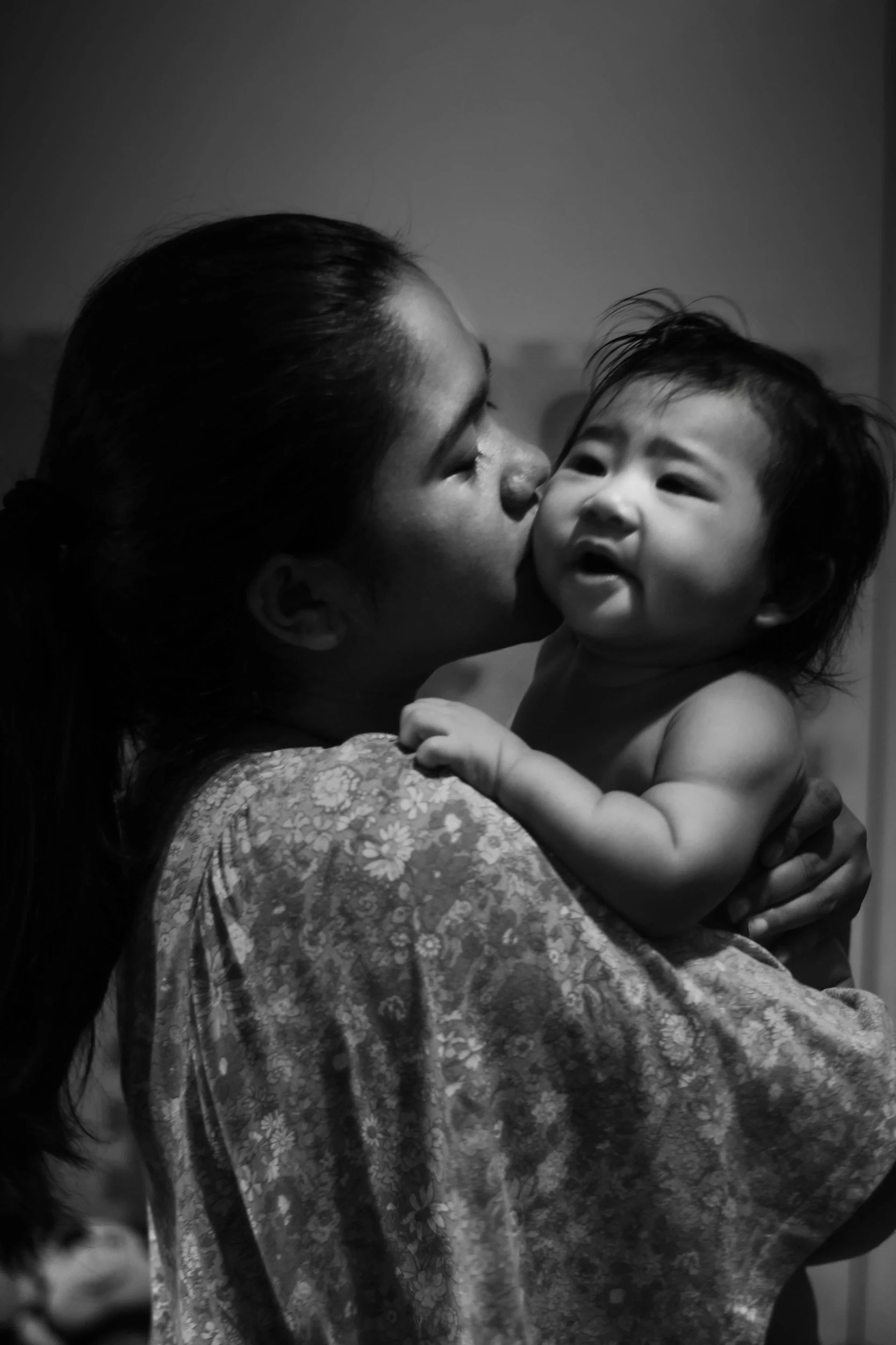 A woman holding a crying baby.