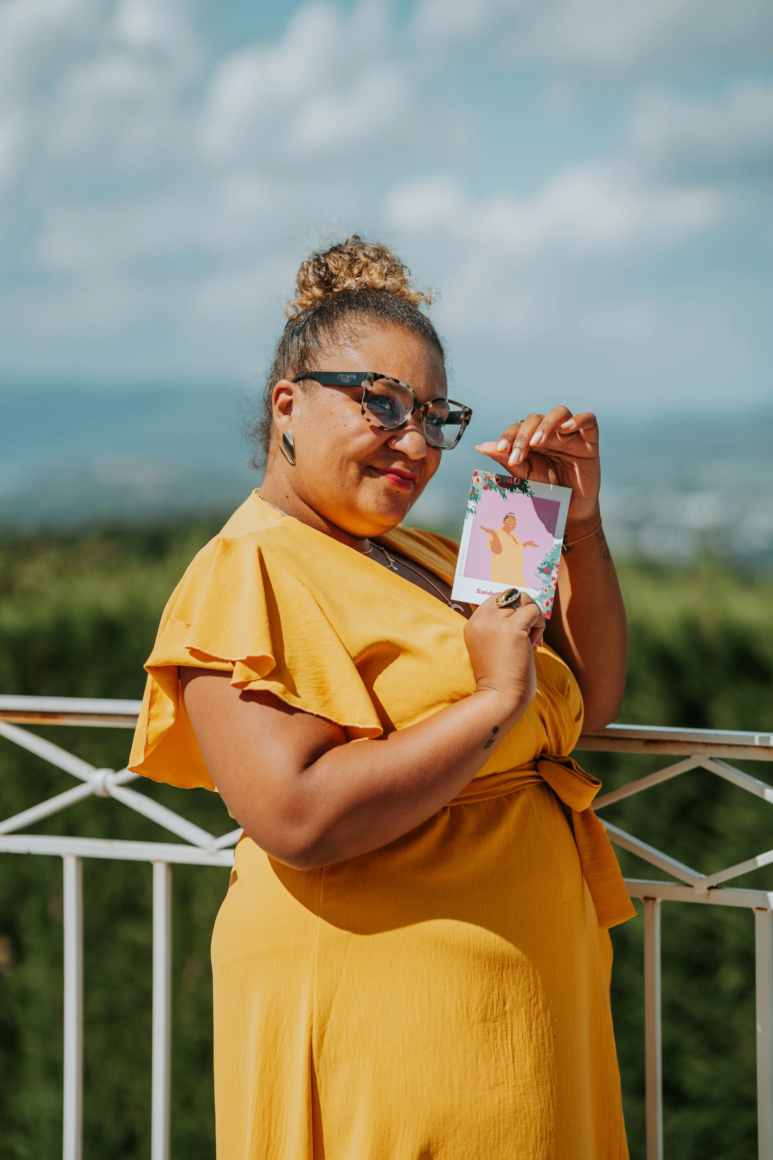Une main tient une illustration de 2 personnes du bar à portraits, souriant et se regardant. La photo est décorée avec des motifs floraux bleus et des signatures, avec les noms 'Déborah et David' et la date '31.05.2020'.
