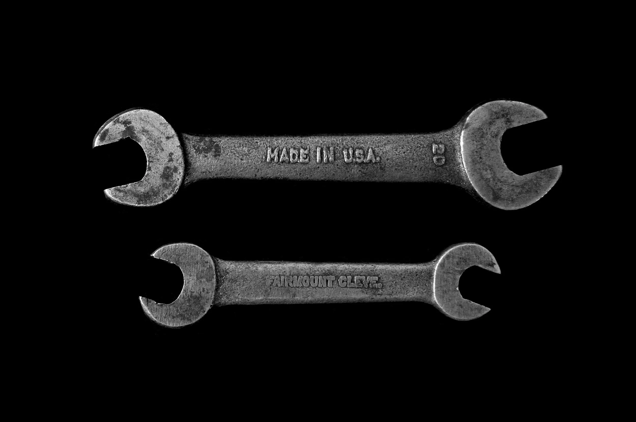 Two metal open-end wrenches with 'Made in USA' and 'Aircraft Grade' engravings, placed on a black background.