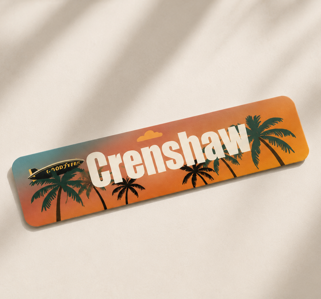 A white surfboard with the word "Crenishaw" in large white letters, island scene with palm trees and a sunset background.