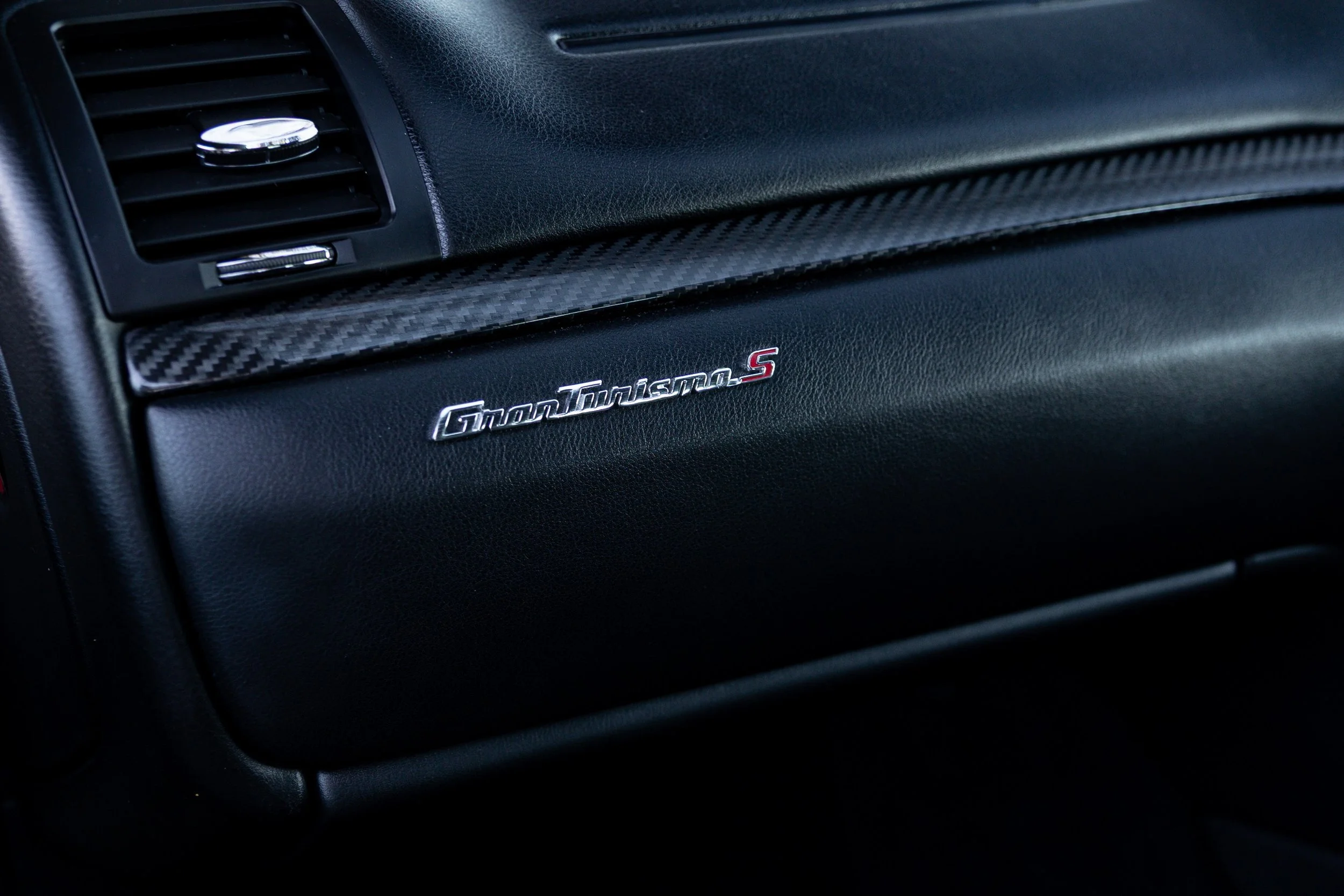 GranTurismo S badge detail on carbon fibre dashboard trim, Maserati interior photography