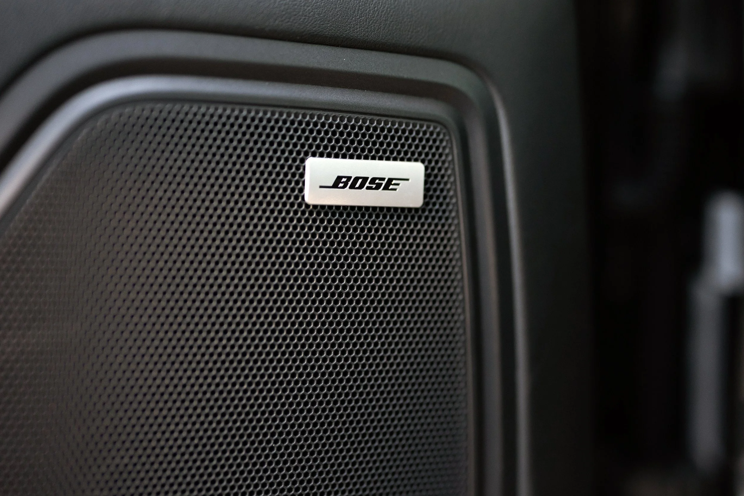 Bose surround sound speaker grille on 2019 Porsche Macan S door panel in black leather