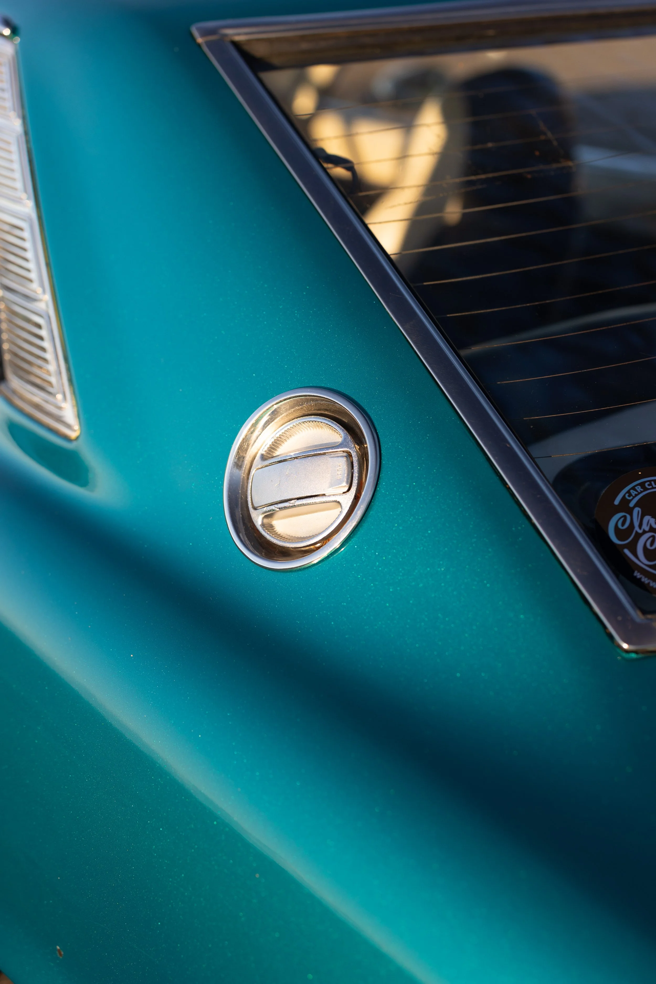 Chrome petrol cap and C-pillar louvre detail on a teal Toyota Celica 1600GT TA22. Classic coupe trim detail photography.