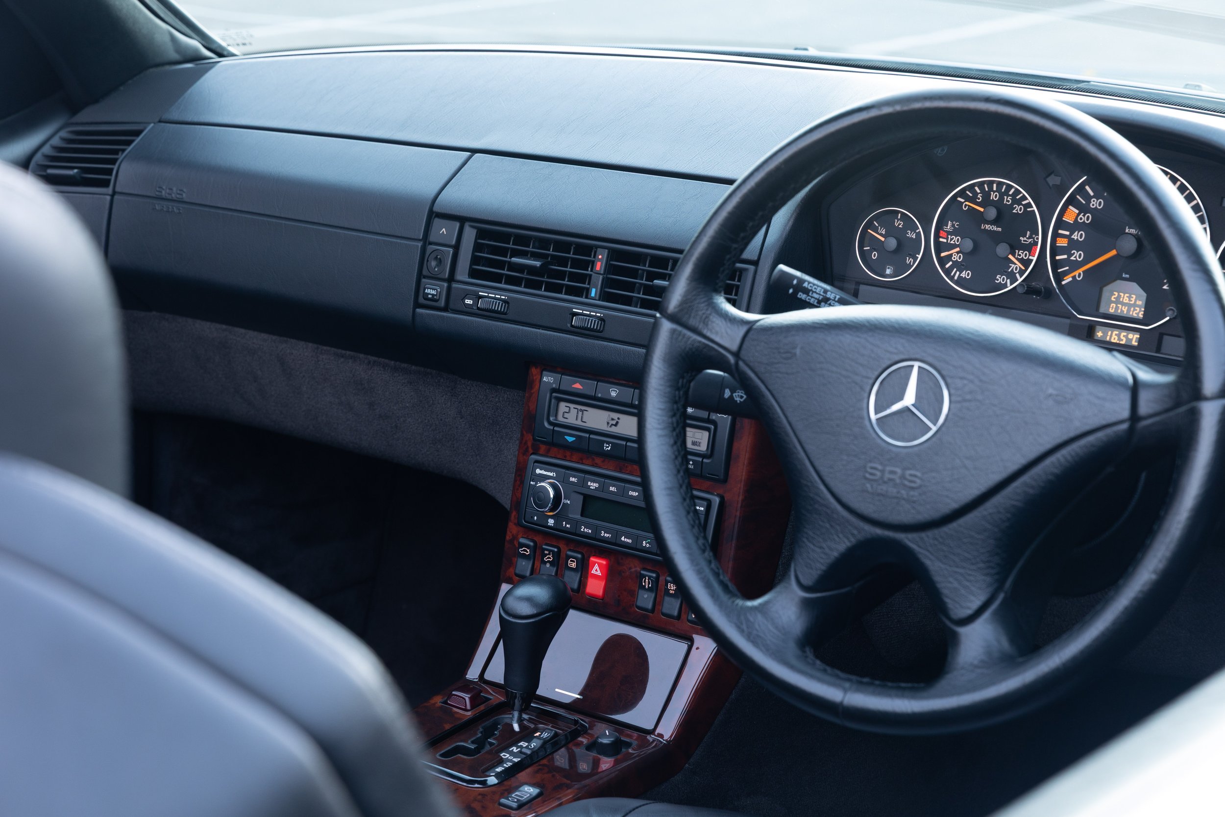 Dashboard and gauges of a 1999 Mercedes-Benz SL 500 R129 with burl wood trim, right-hand drive.
