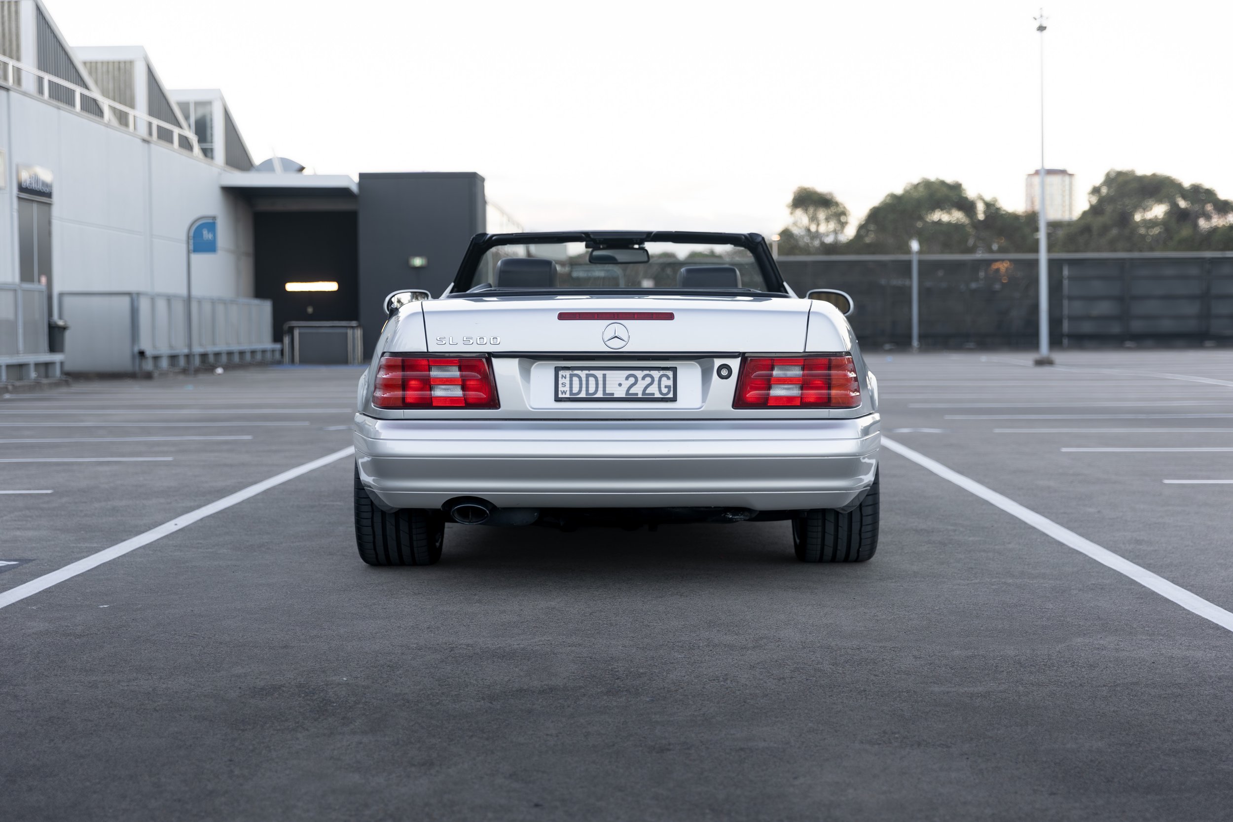 Silver 1999 Mercedes-Benz SL 500 R129 straight rear view, top down, Sydney.