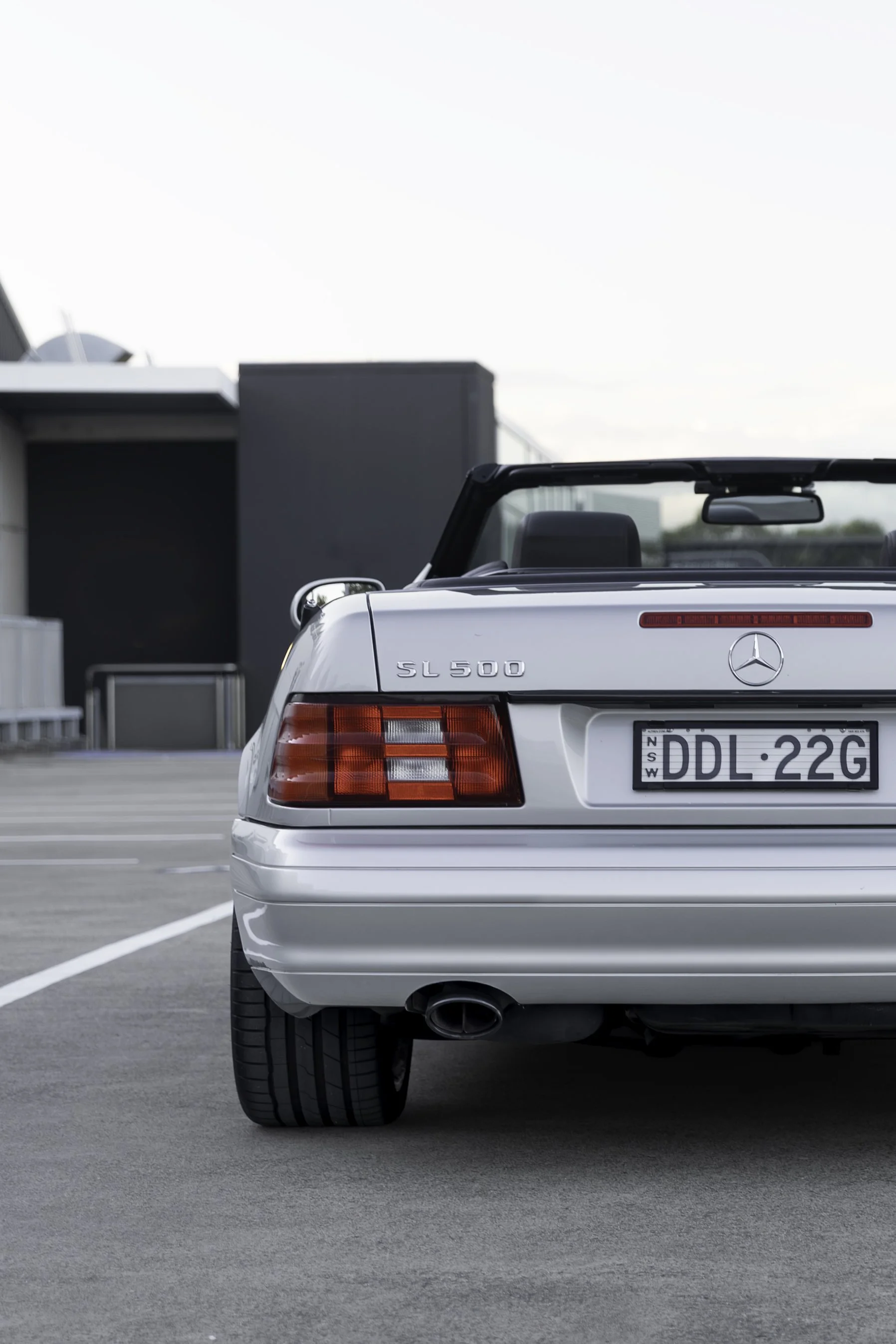 Rear and tail-light detail of a silver Mercedes-Benz SL 500 R129 roadster, Sydney.