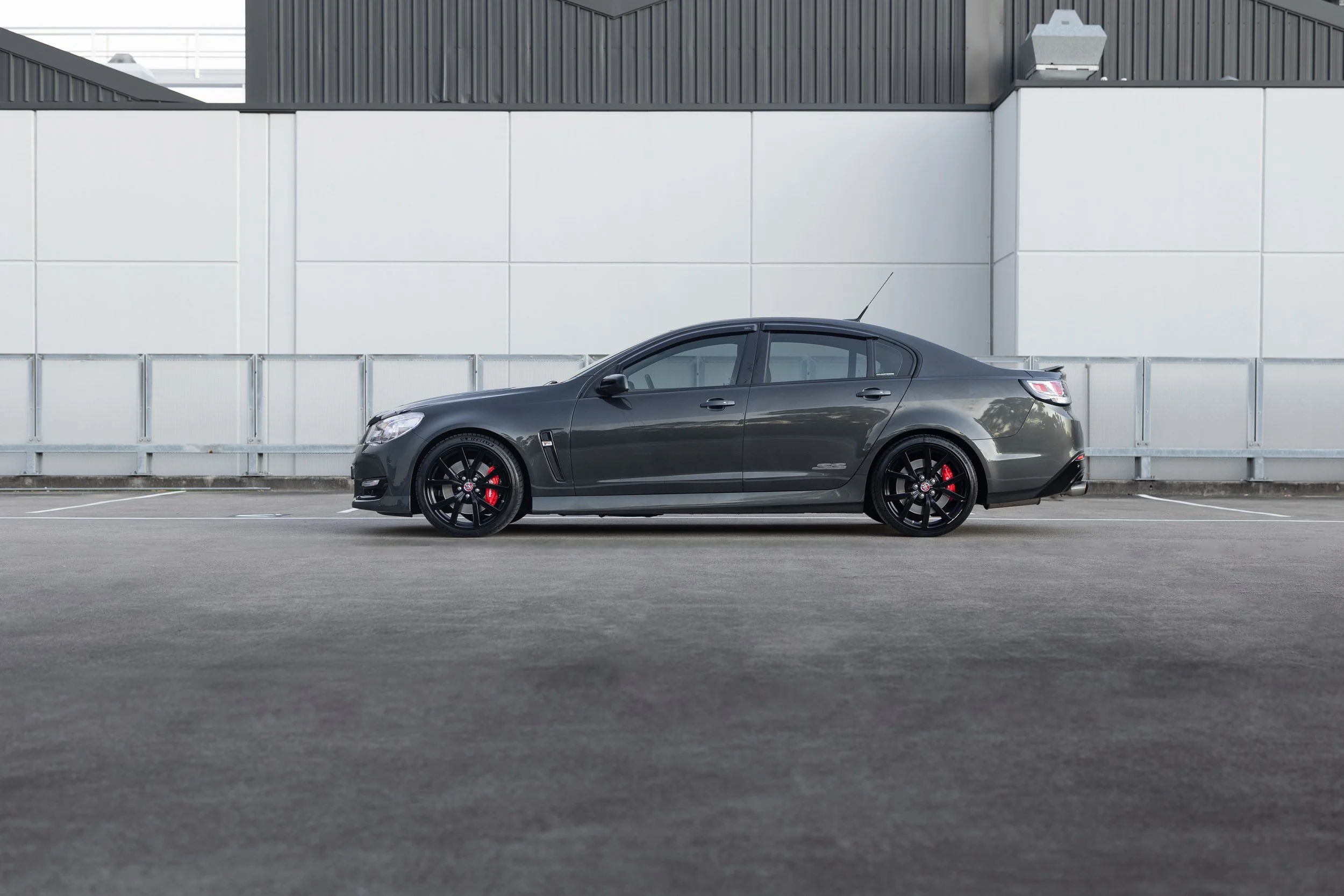 Side-profile automotive photography of a dark grey Holden Commodore SS V Redline