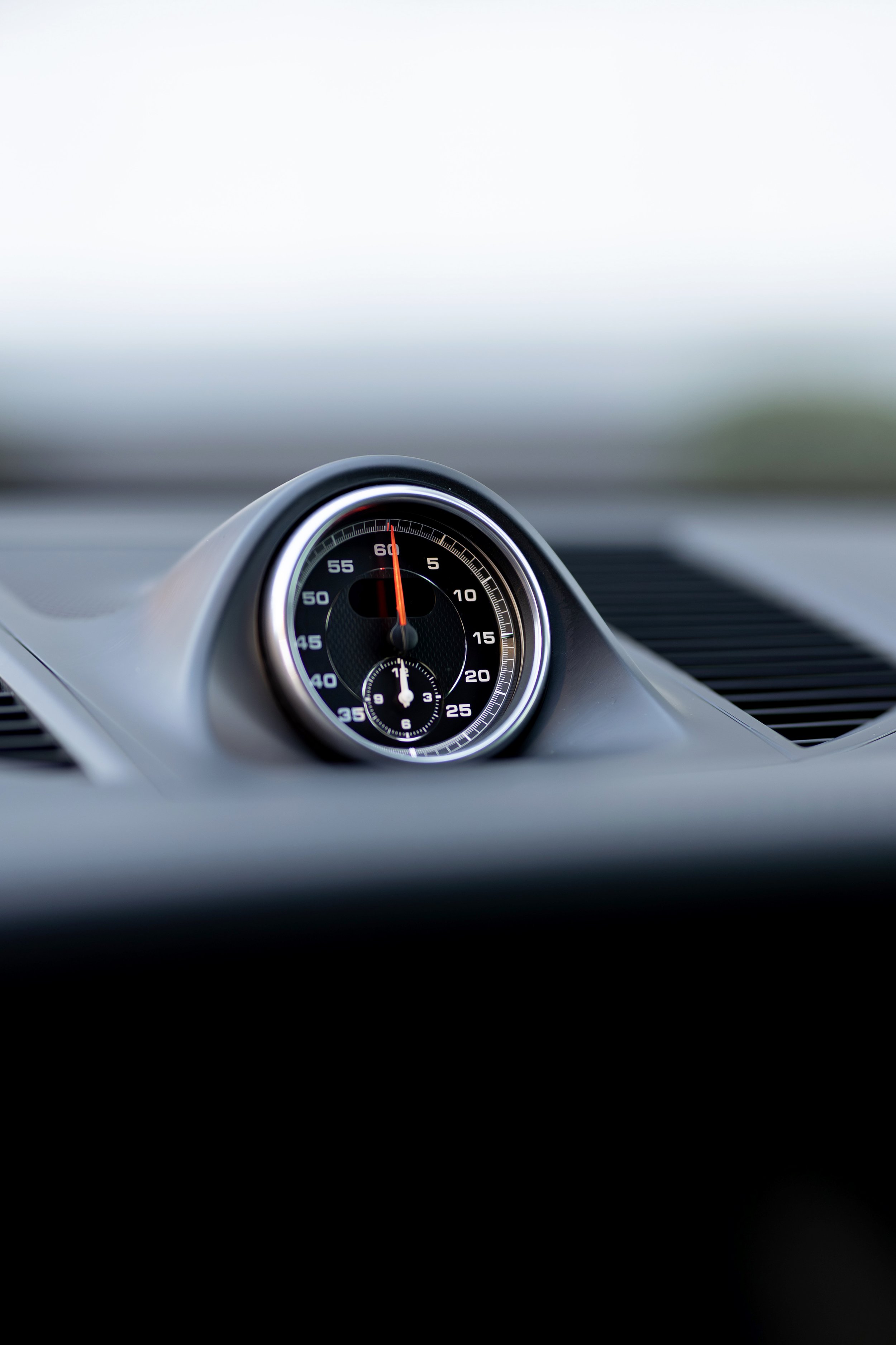 Porsche Sport Chrono Package stopwatch close-up on 2019 Macan S dashboard, orange needle