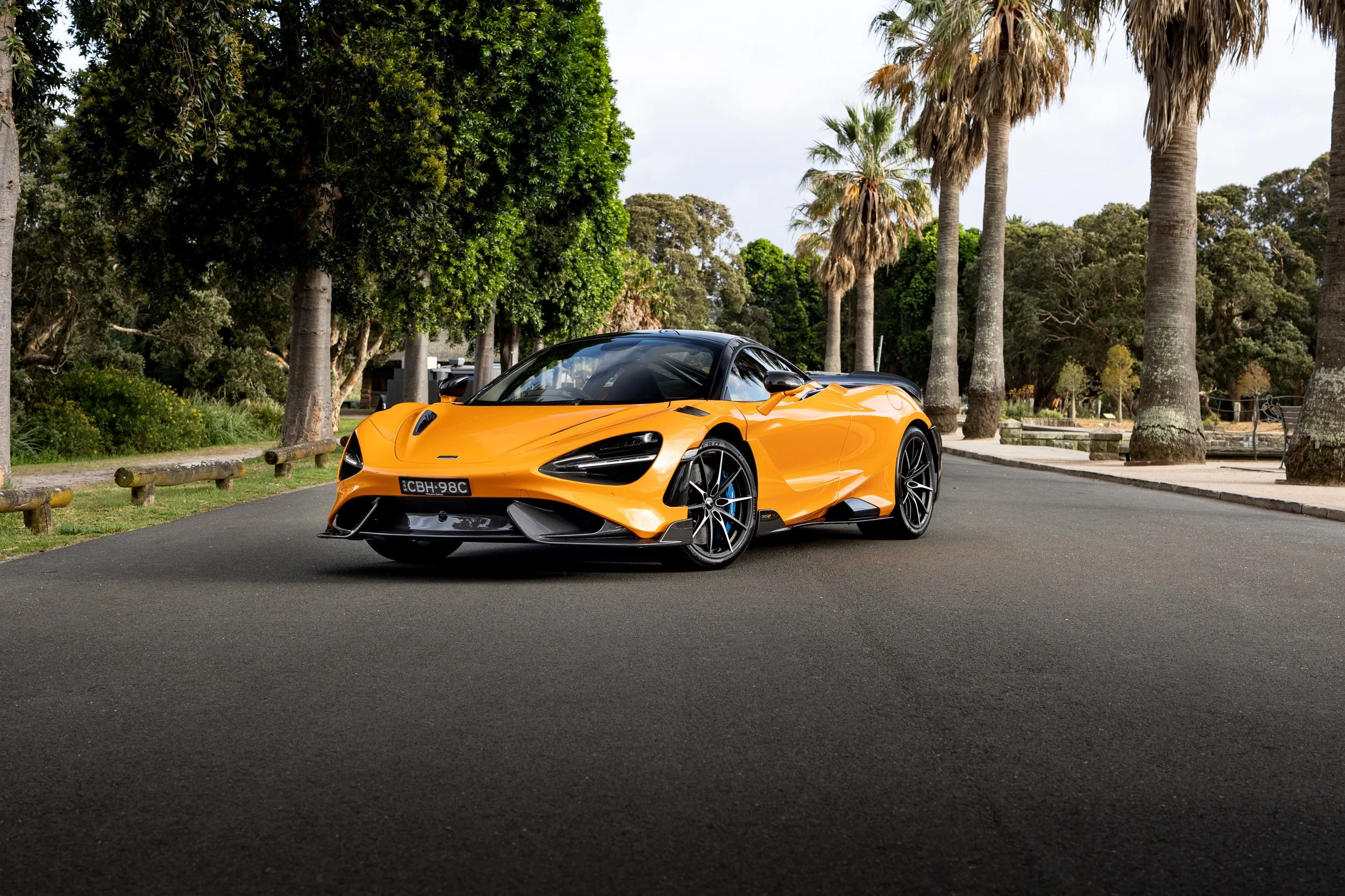 Front three-quarter view of McLaren 765LT Papaya Spark, low stance emphasising sharp supercar proportions.