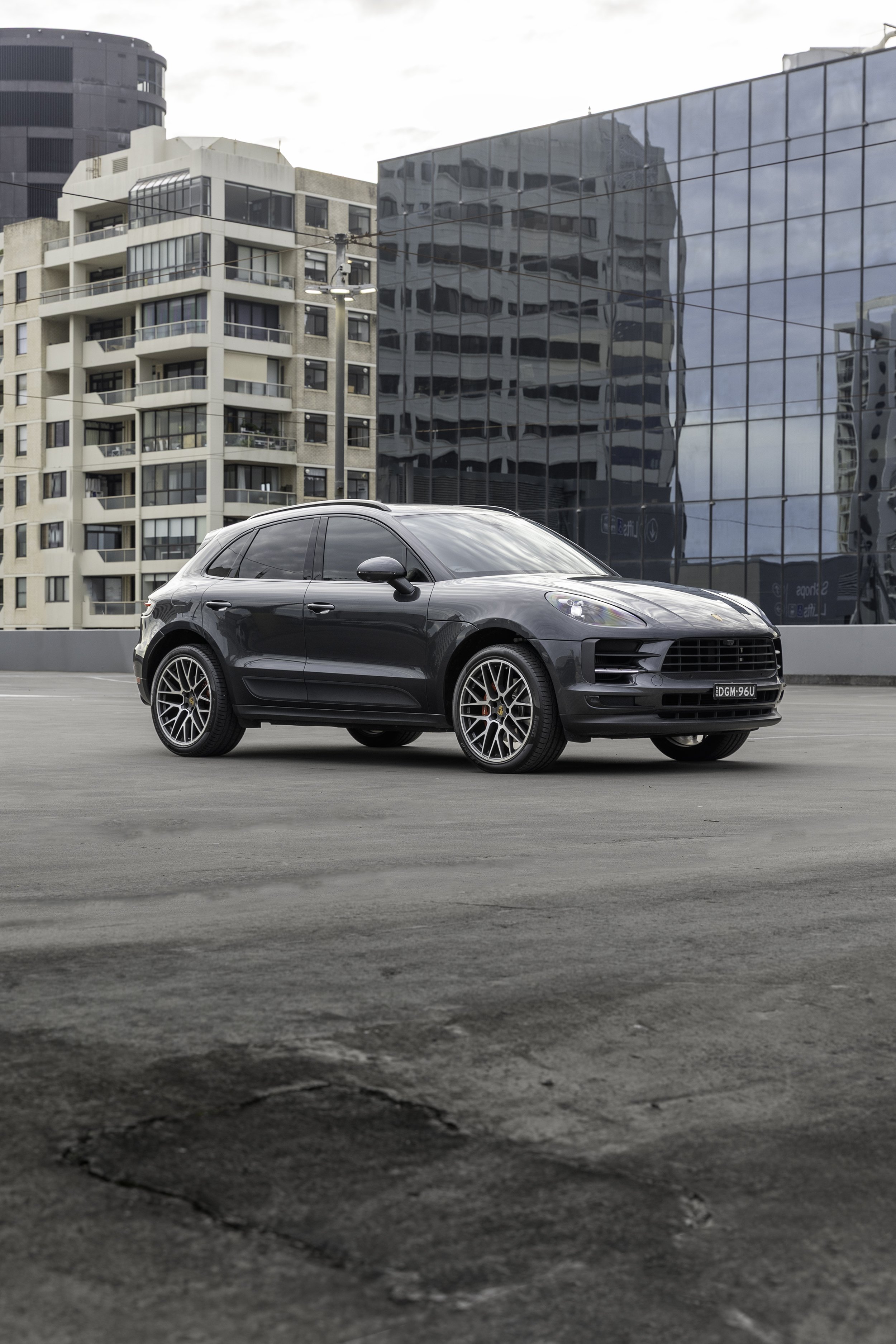 2019 Porsche Macan S in Volcano Grey Metallic, front three-quarter view, Sydney rooftop with glass building backdrop