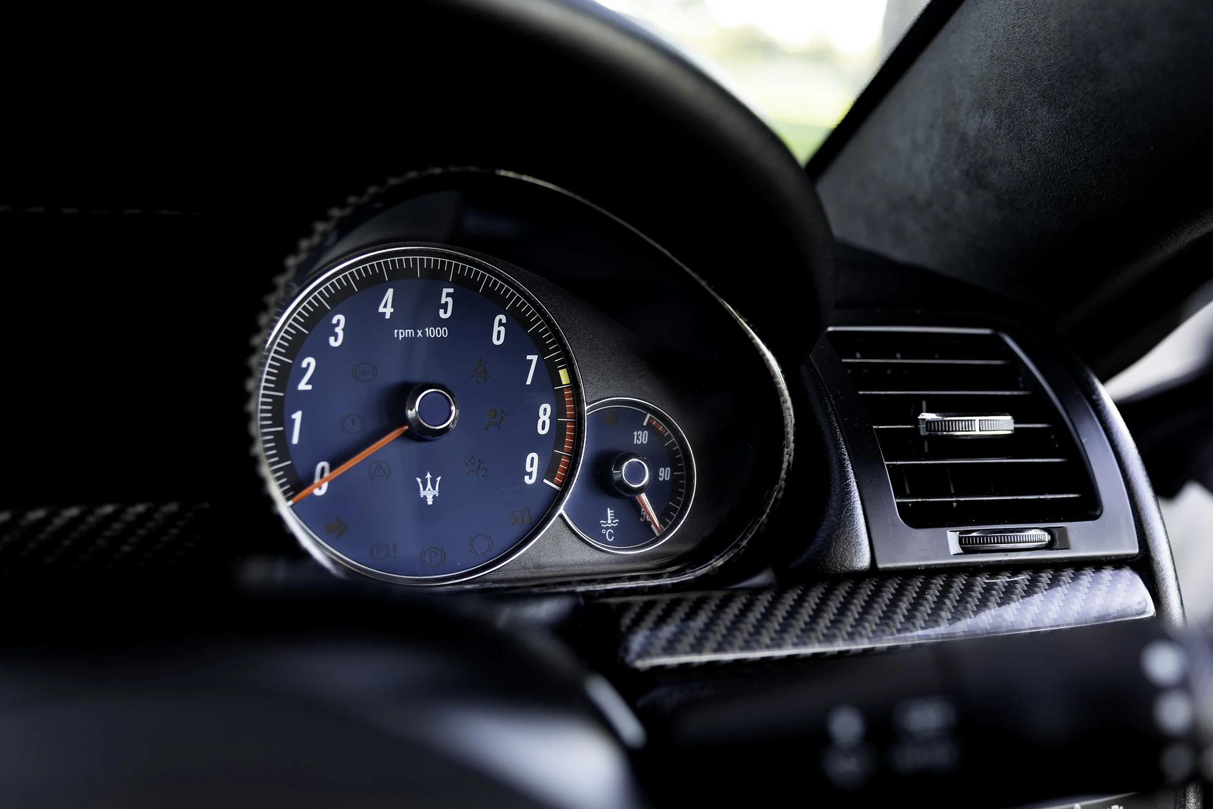 Maserati GranTurismo S tachometer close-up, carbon fibre bezel, automotive detail photography
