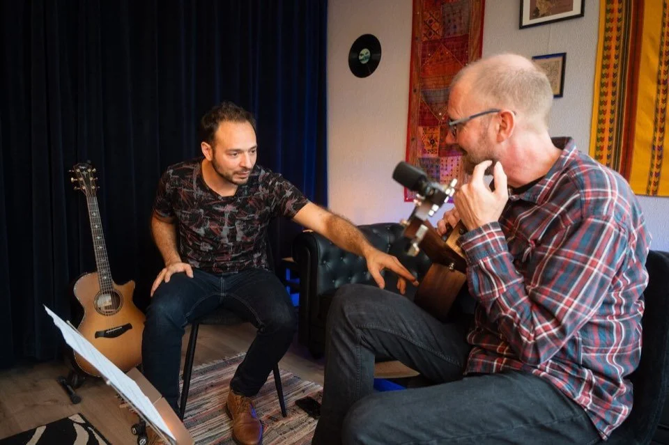 Cours de guitare acoustique pour adulte à Saint-Gilles, Bruxelles: le professeur explique un morceau à son élève