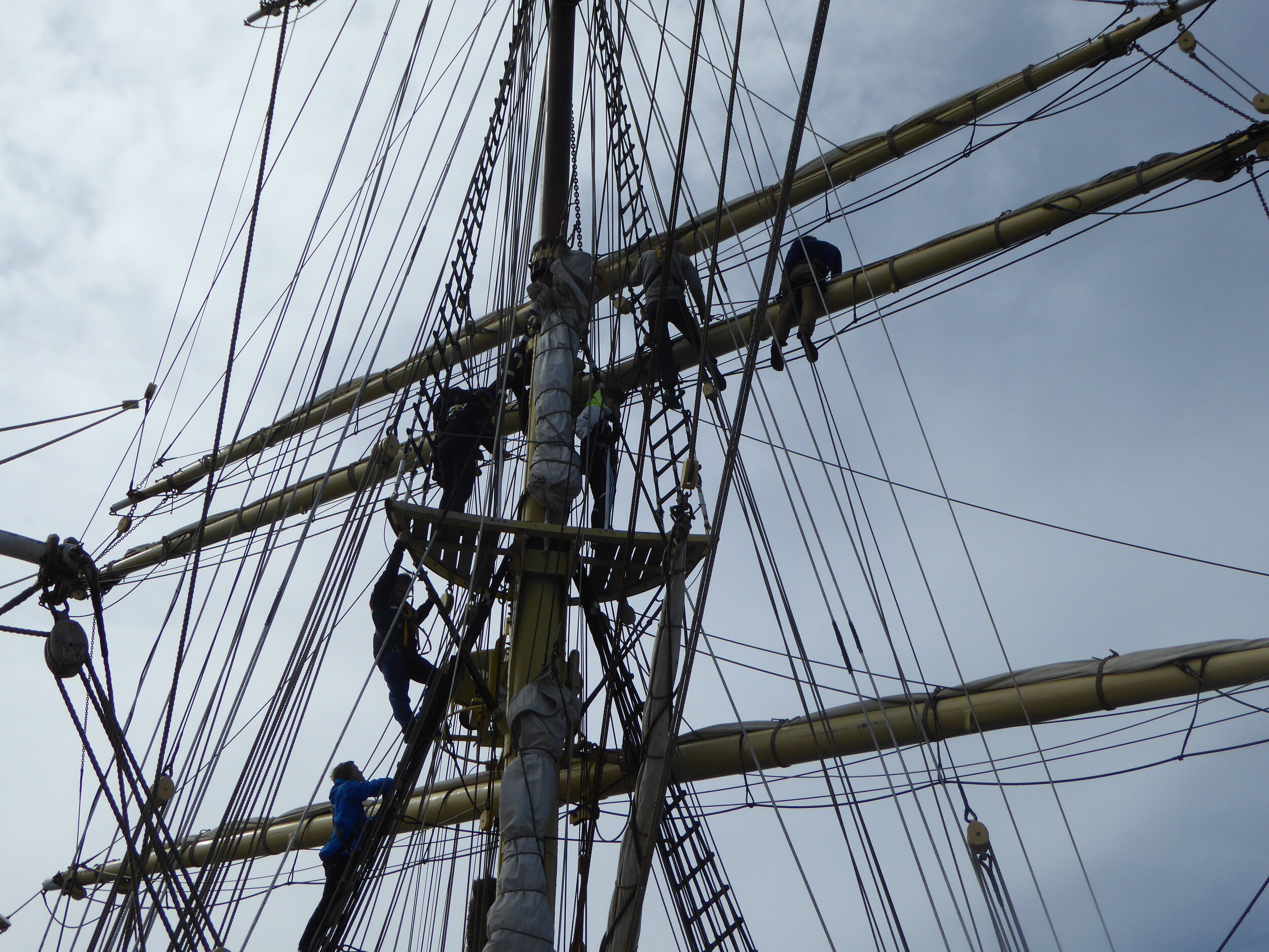Then trainees put on their harnesses and climb up to untie the sails from the yard. 