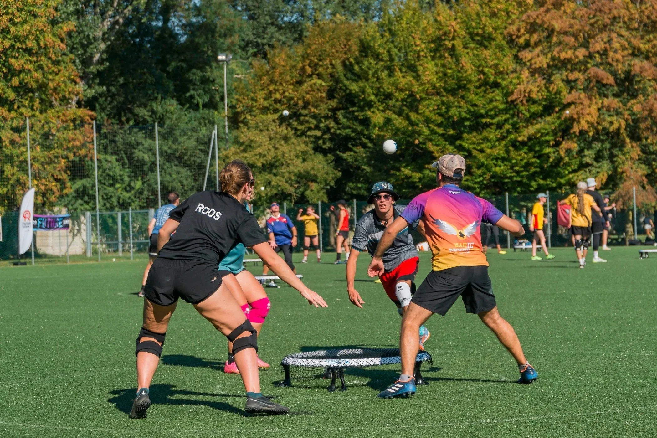 A group of women playing a game outdoors with a crowd of spectators watching.