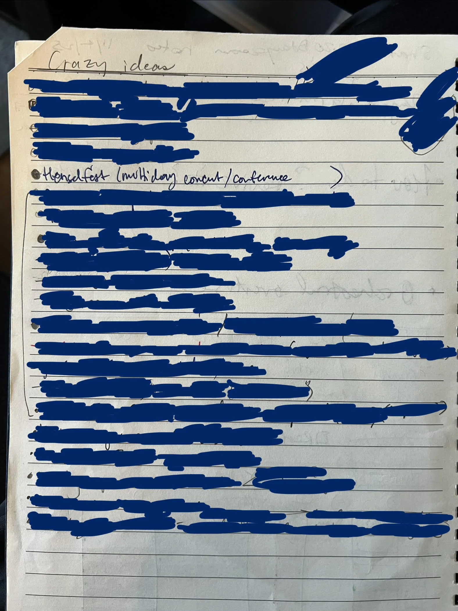 A photograph of a page in a lined notebook. most of the lines are blacked out, but the top of the page says "Crazy ideas", and the only visible item on the list (row 5 of 21) says "Henselfest (multiday concert/conference)