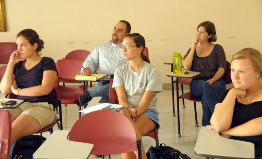 Students and faculty listen attentively to the details of the research.