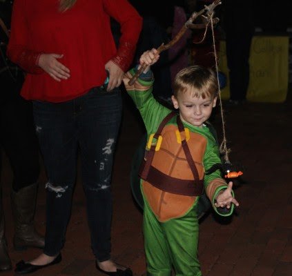 A Teenage Mutant Ninja Turtle adjusts his fishing rod.