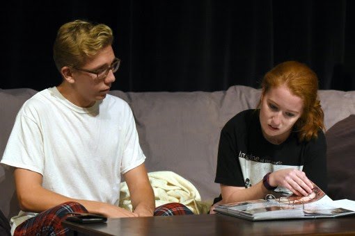 Emily and Stephen glance at ‘the book’ which contains memories from past roommates come and gone.