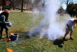Students have fun while throwing different-colored powders at one another
