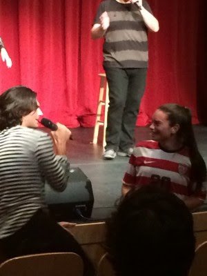 Mike Celia sings to a student in the audience.