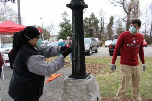 These students work to clean up the lampposts in front of the Armory.