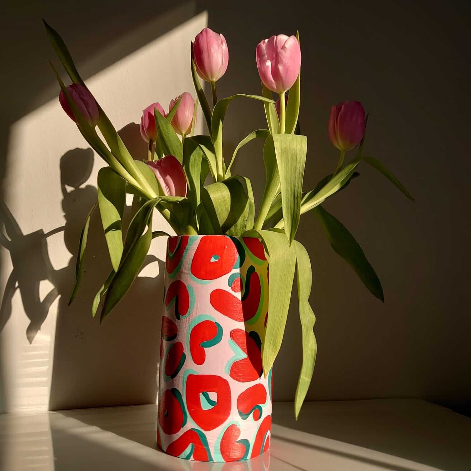pink and red leopard print vase with tulips