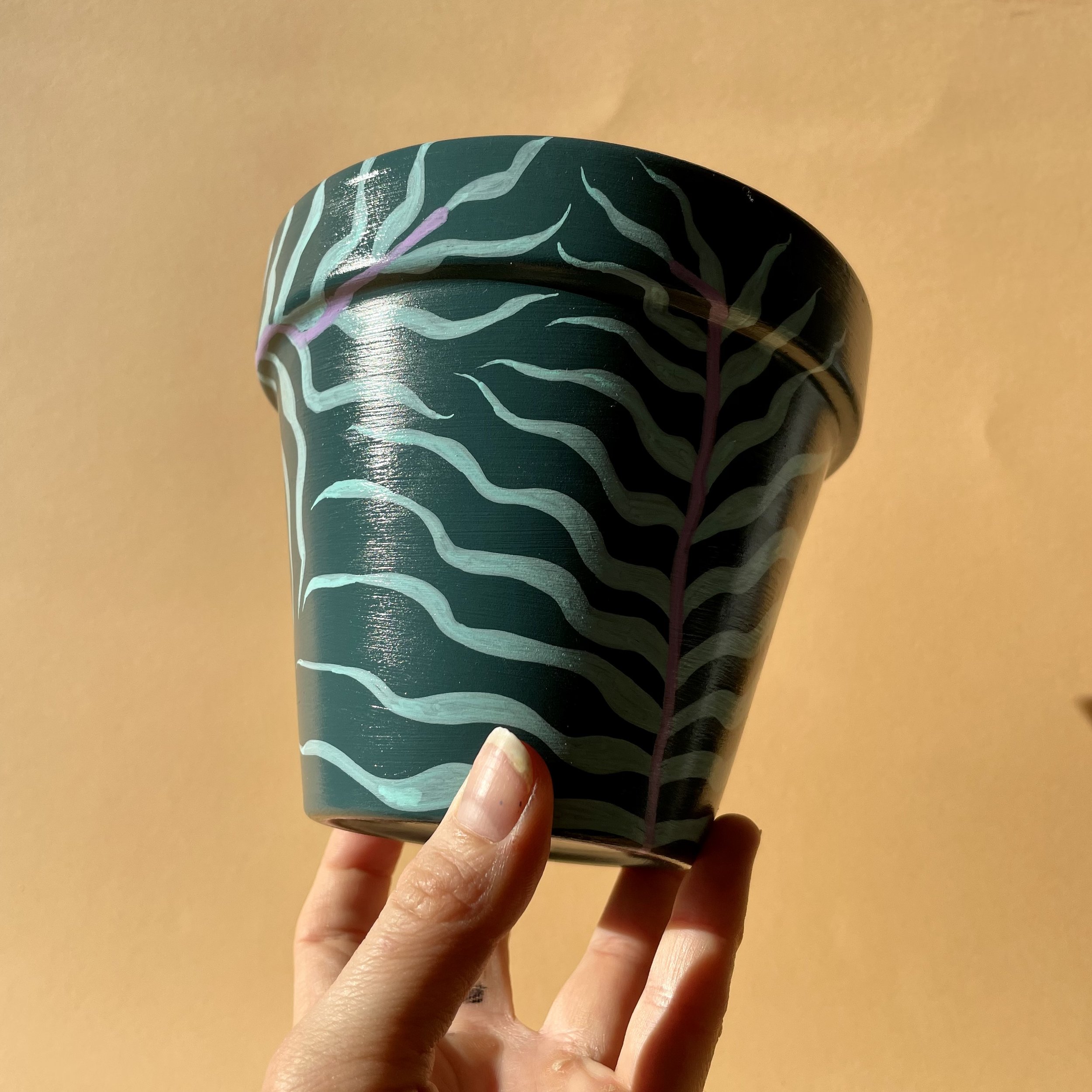 teal green plant pot with palm print