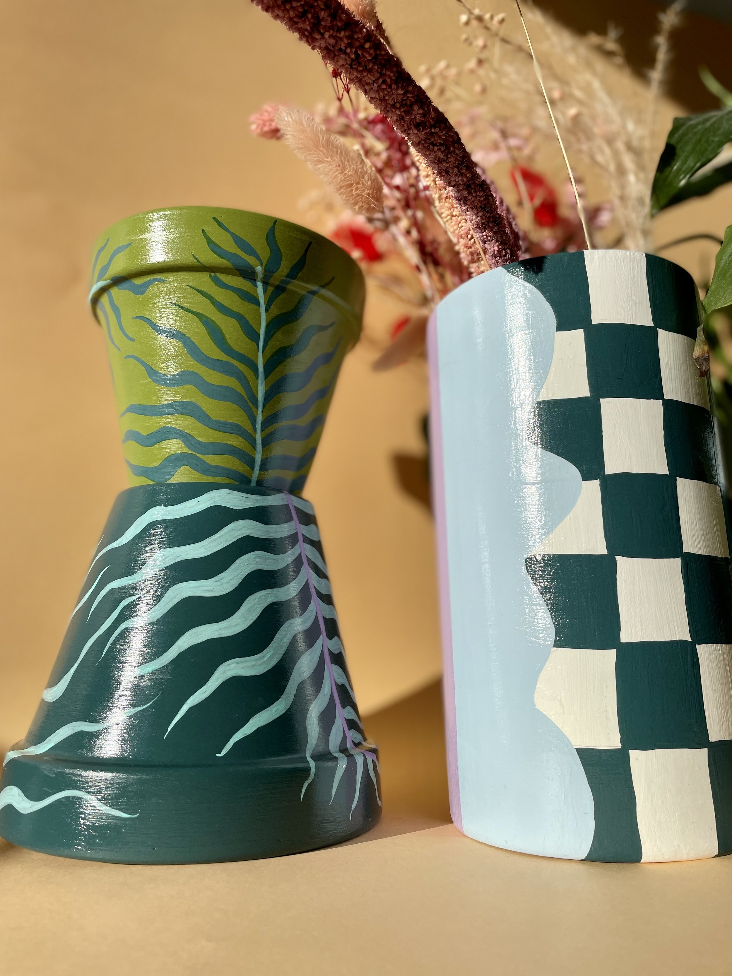 green plant pots with a checkered vase