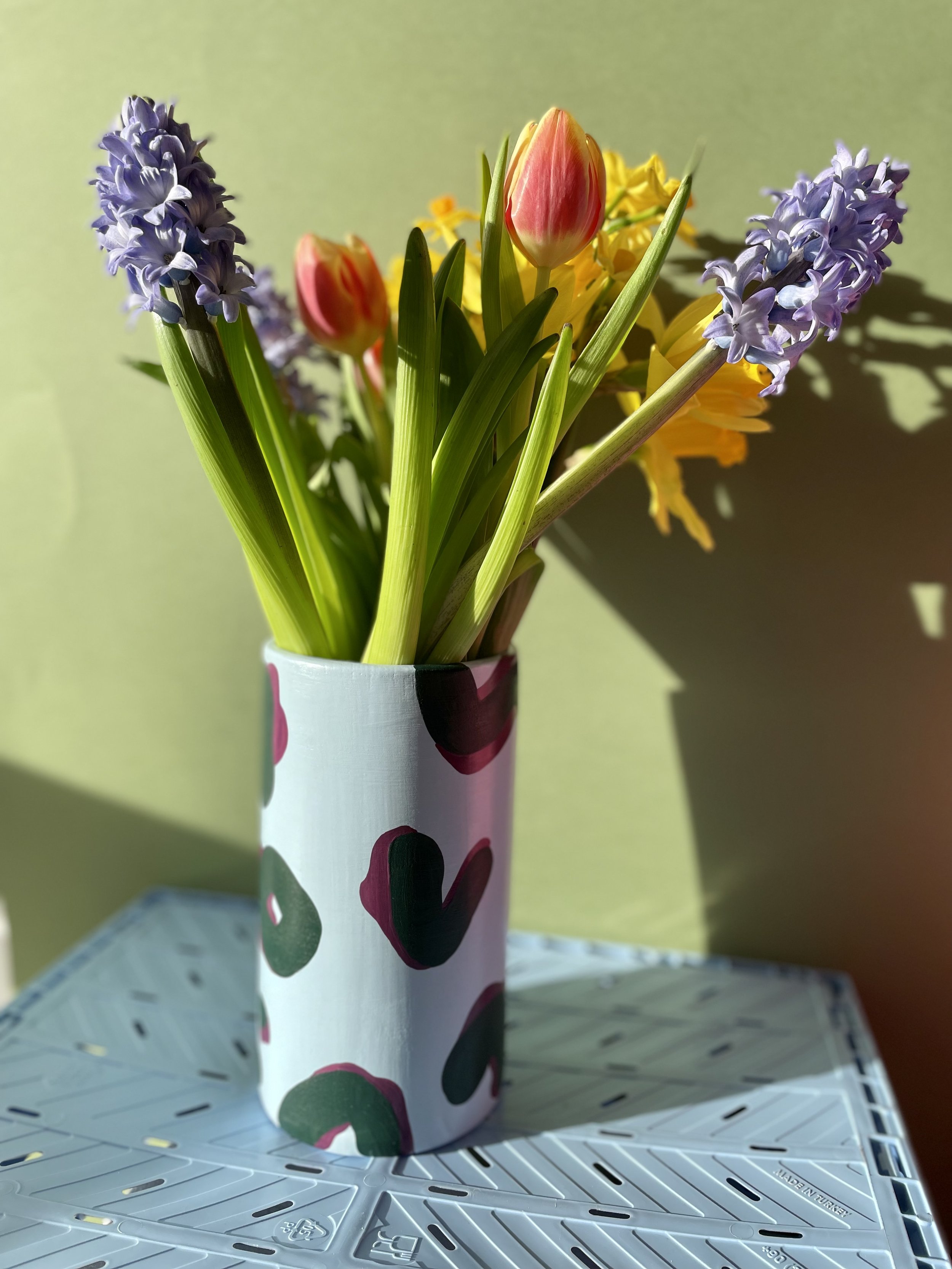 colourful flowers inside a large cylinder vase
