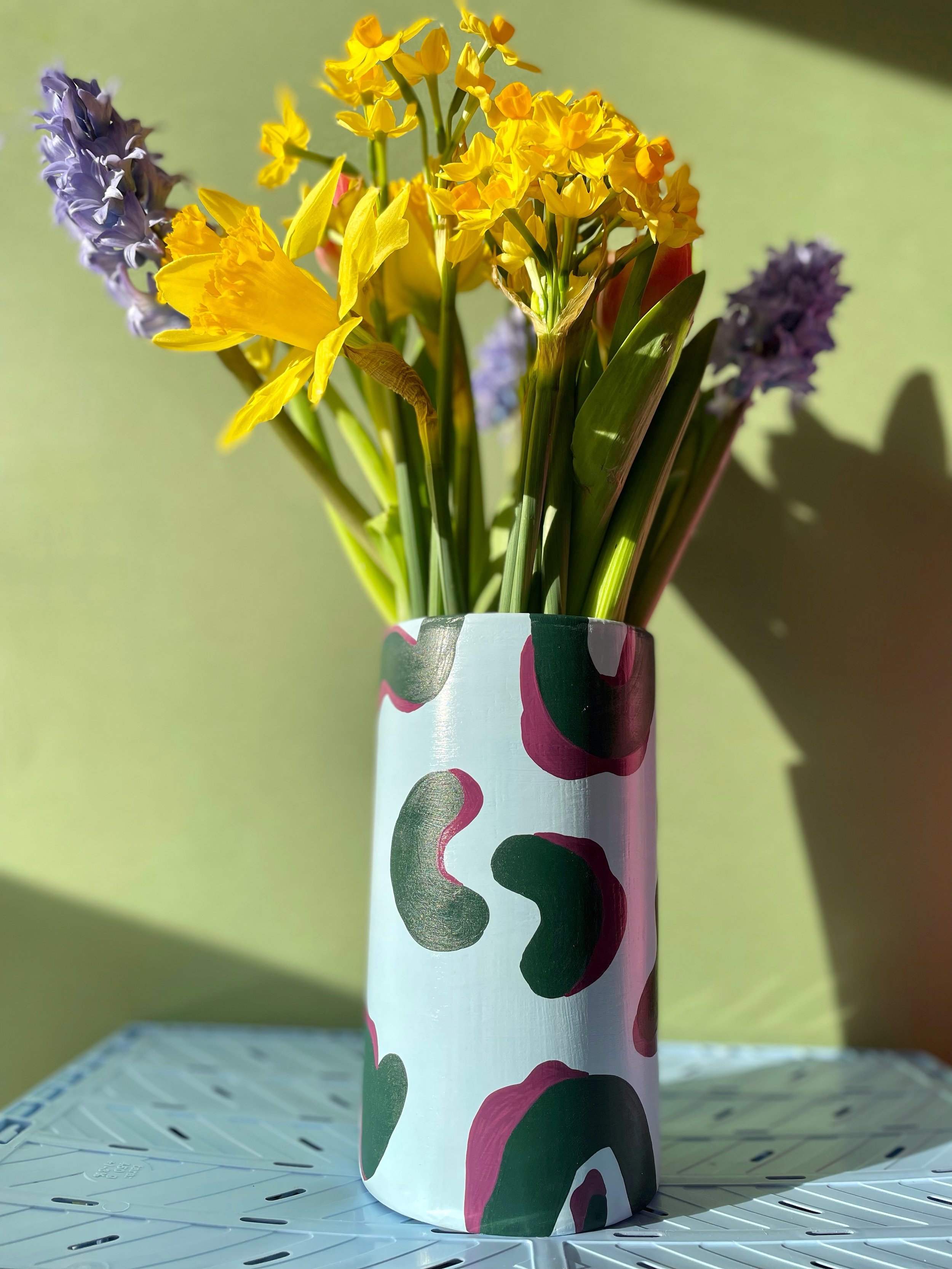 colourful flowers arranged in a large cylinder vase