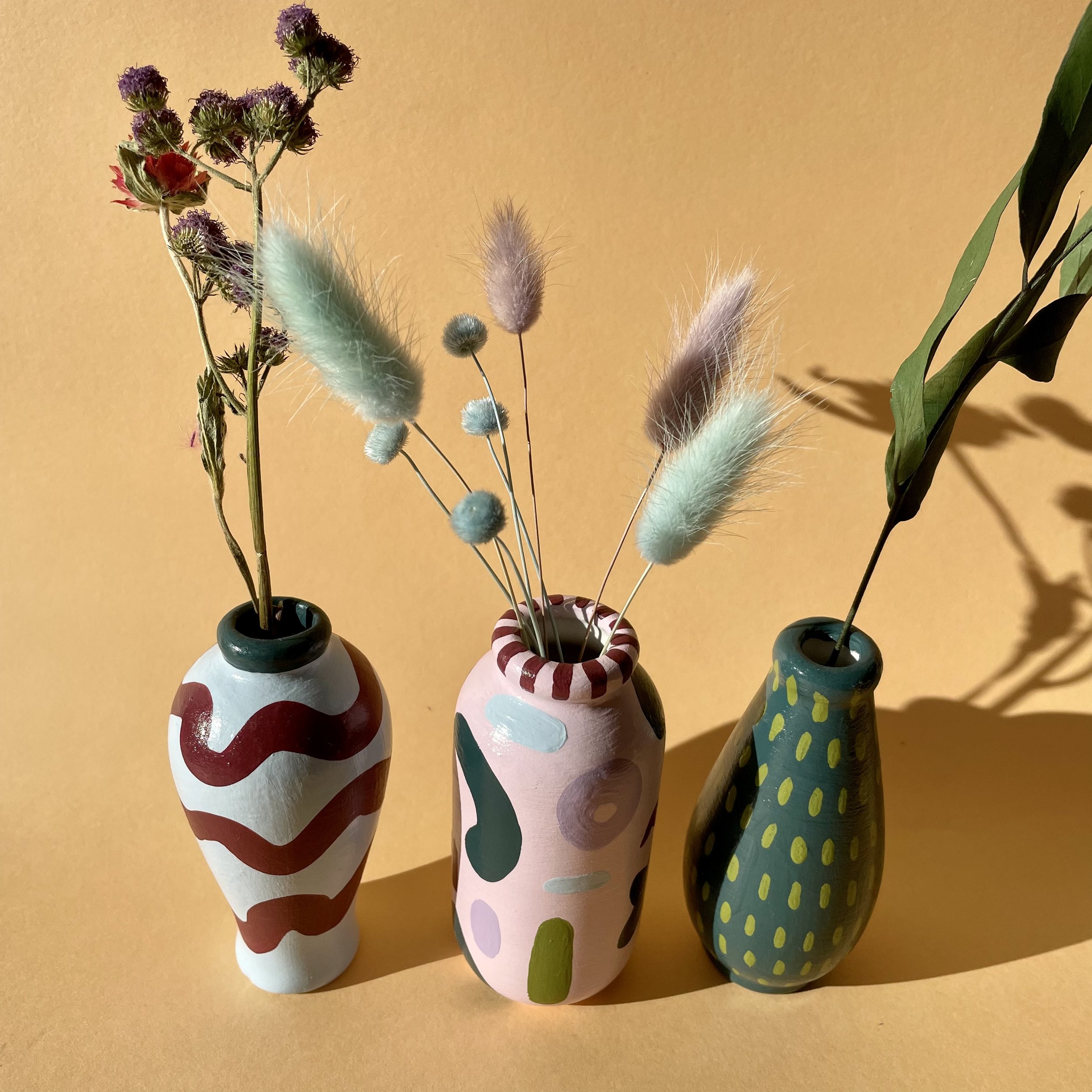 stem vases filled with dried flowers