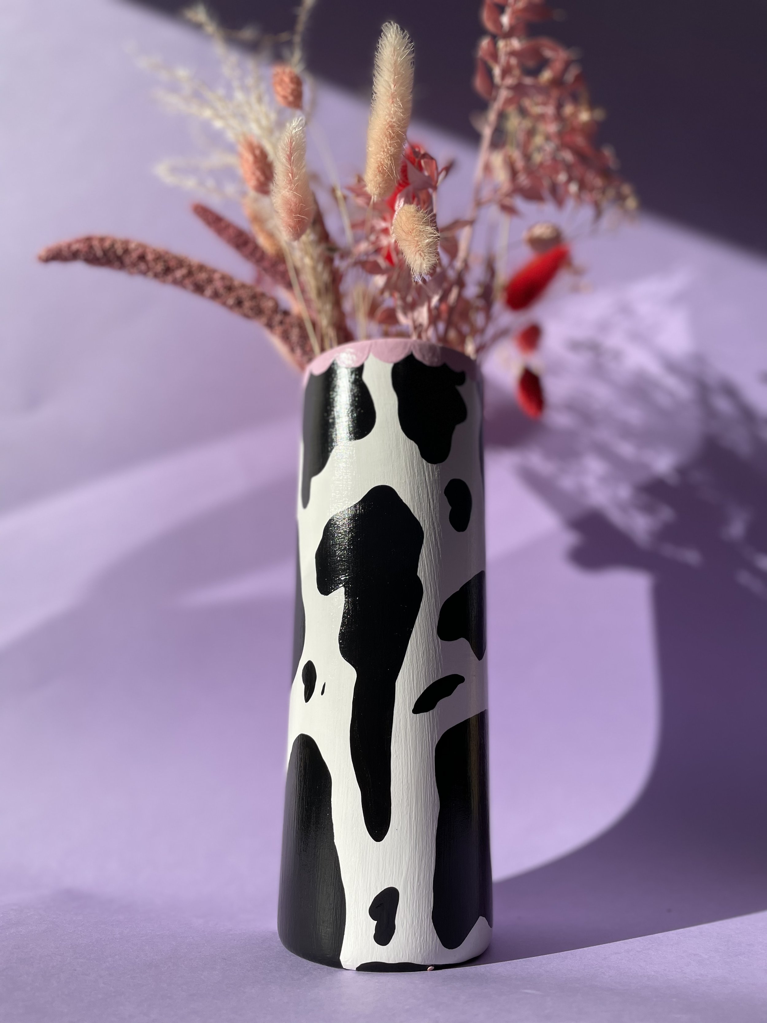 white and black cow print vase