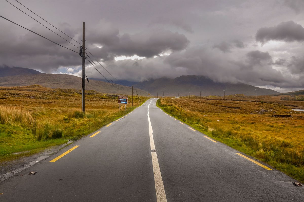 dramatic skies over a connemara road wild atlantic way rachel dubber