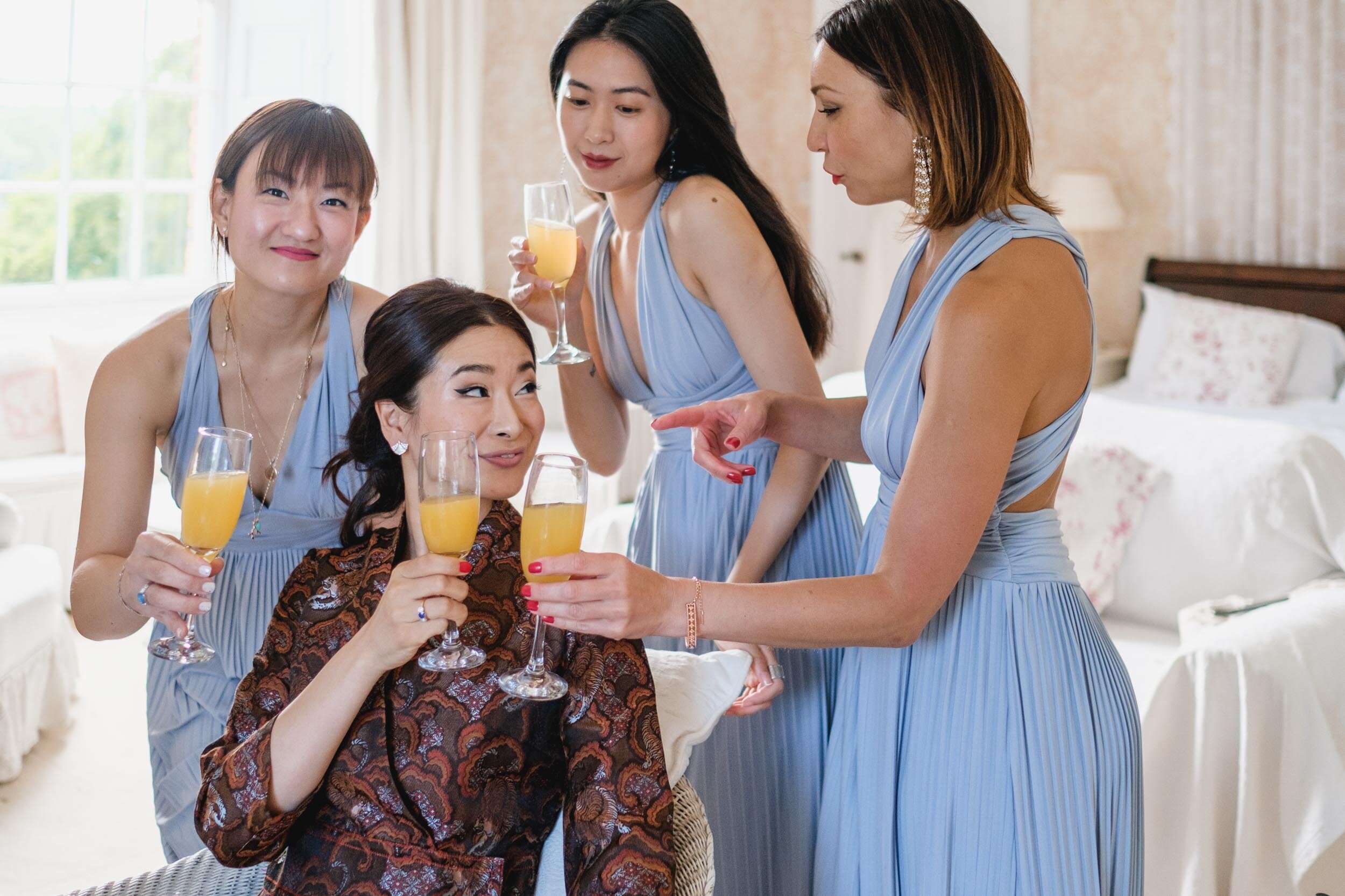 bride and bridesmaids toasting each other