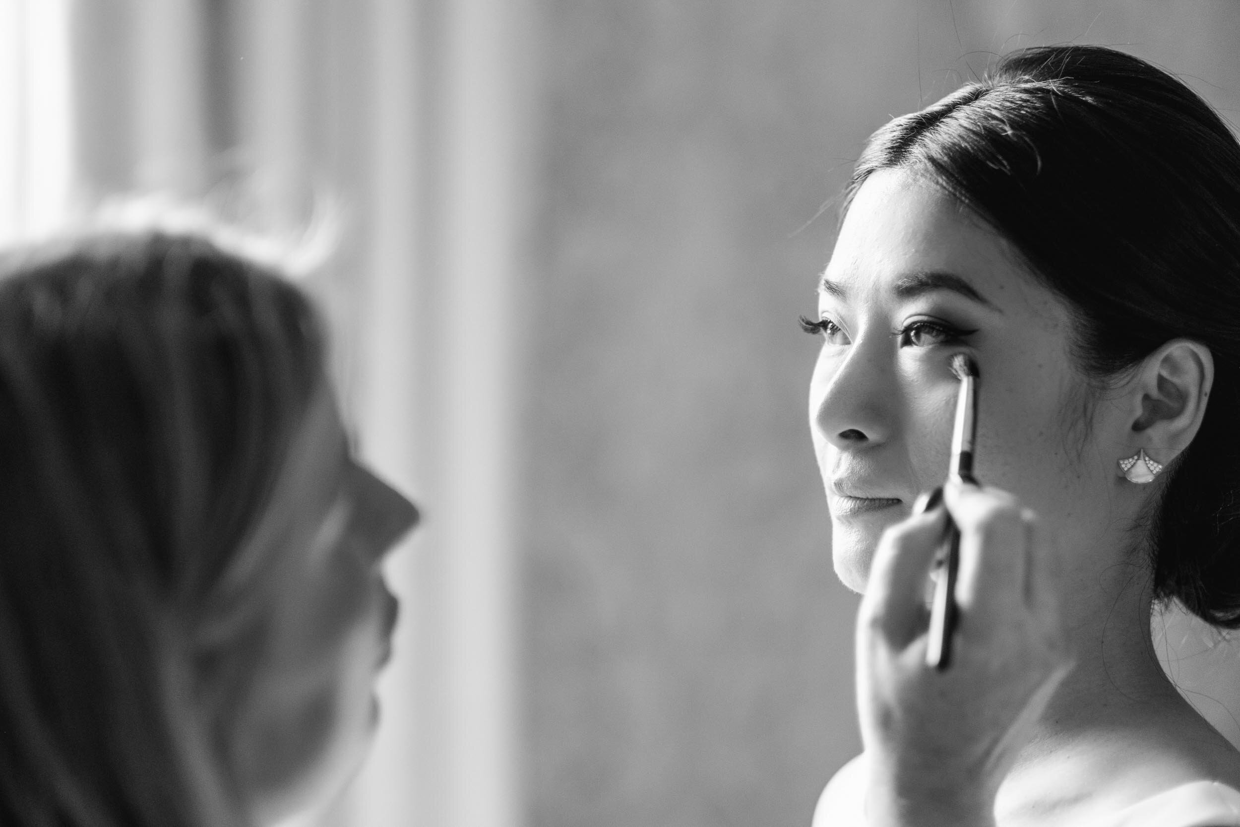 bride wearing bulgari earrings having her makeup applied