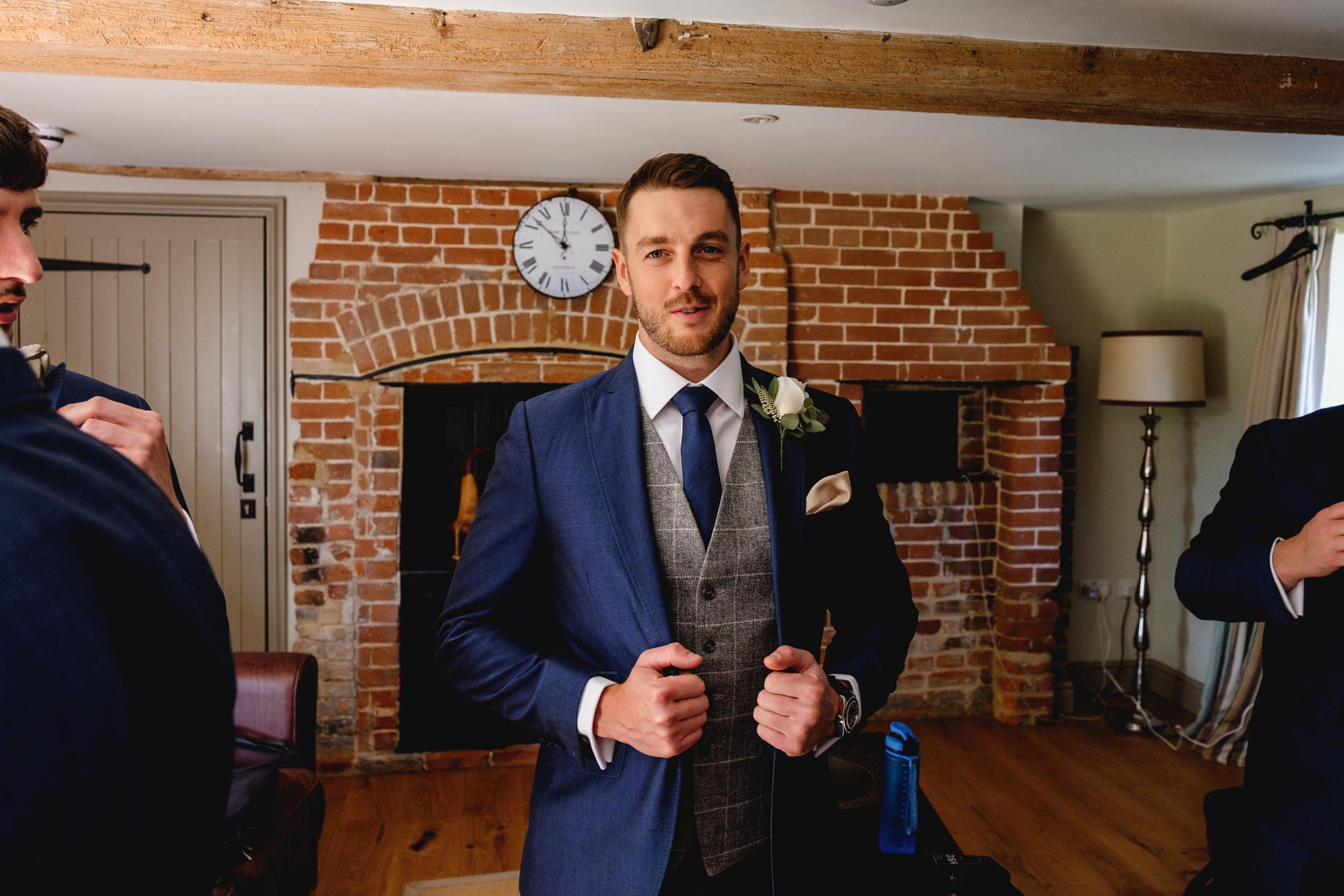 groom wearing a blue suit and tweed waistcoat