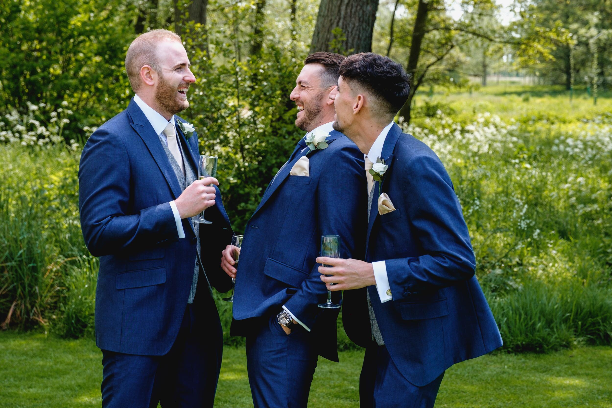 groom and best men share a joke at easton grange, a wedding venue in Suffolk
