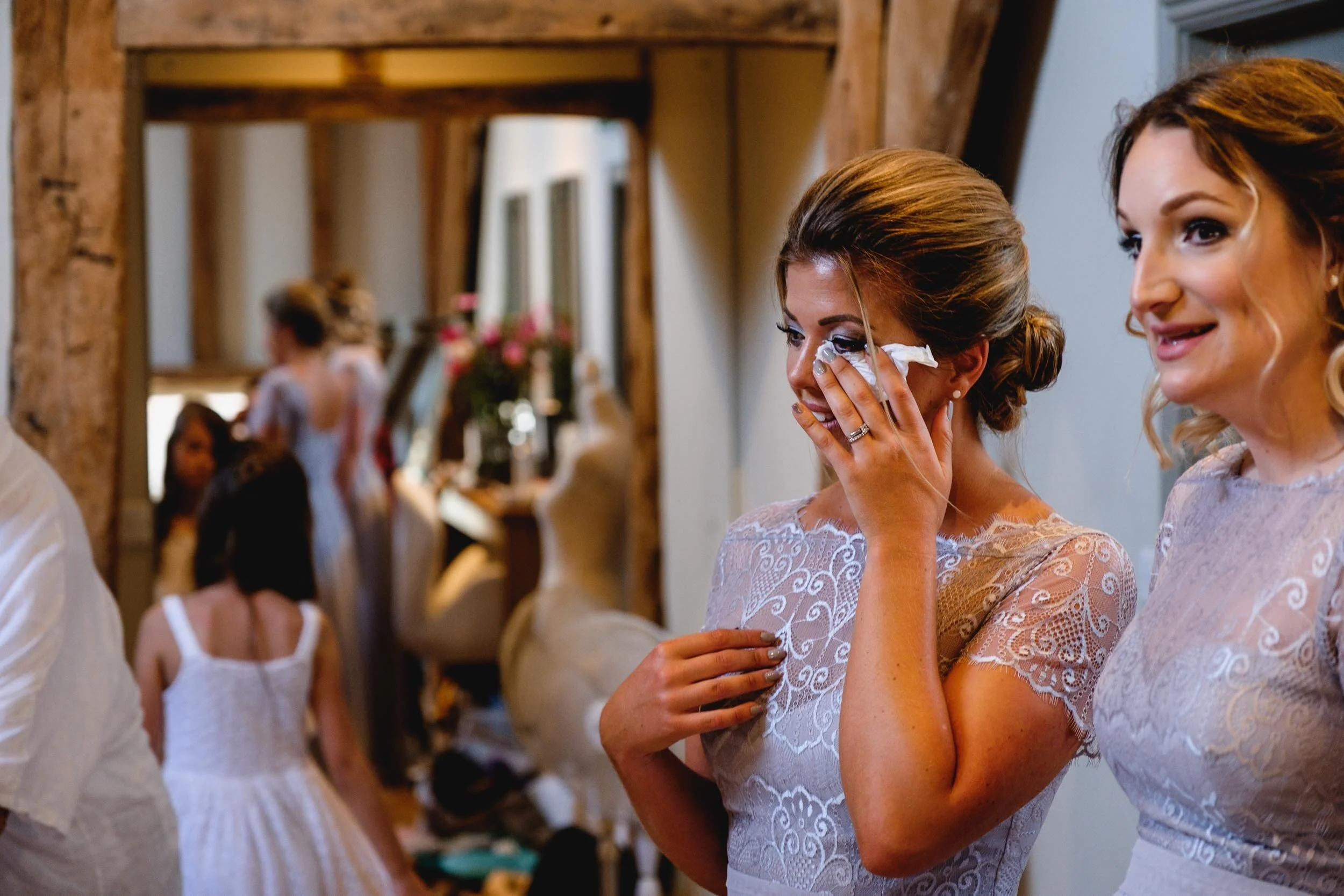a bridesmaid wipes away a tear