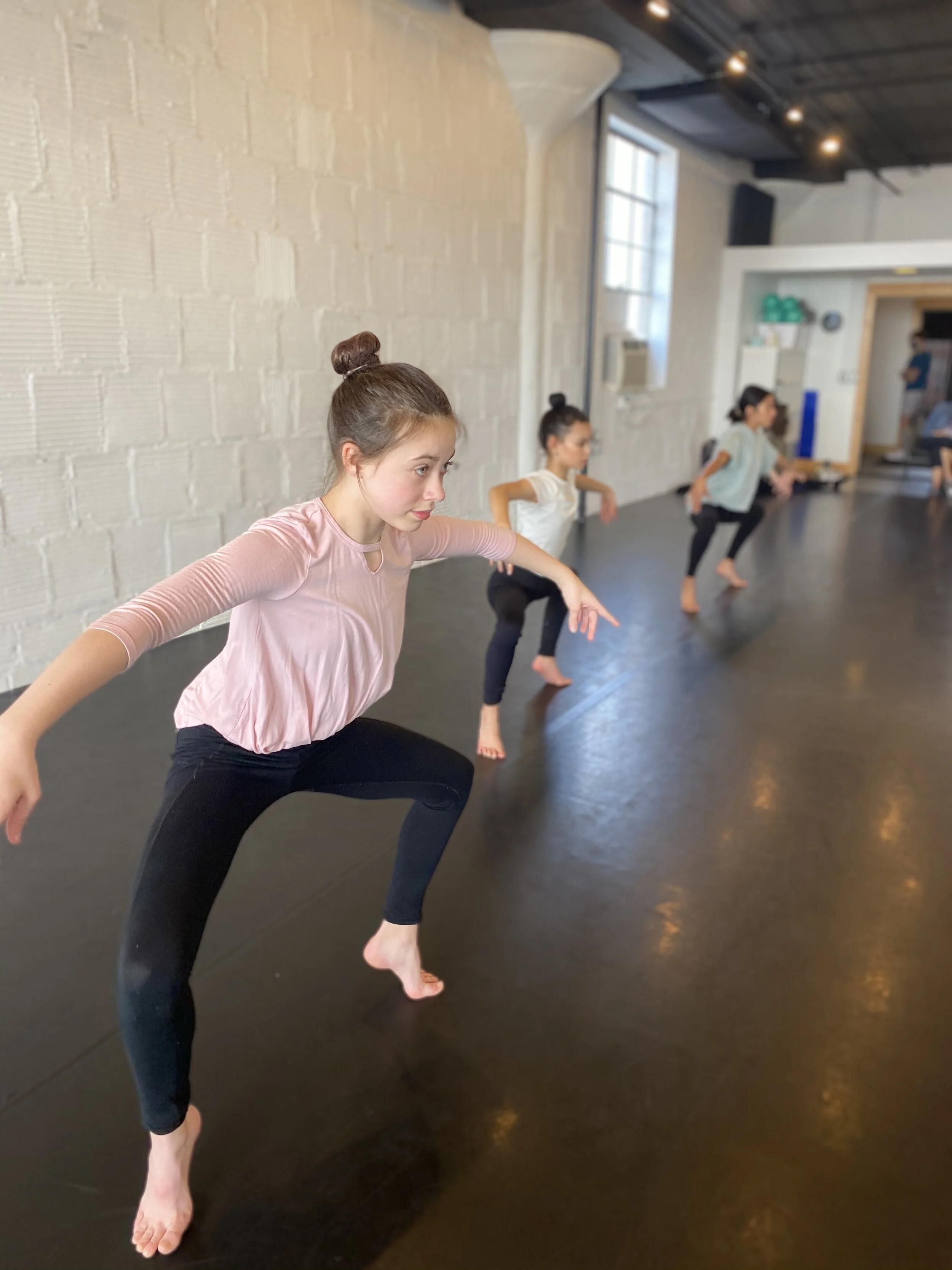 forced arch stretching hair in bun pink shirt girl Dance acting ballet jazz lyrical contemporary theater musical camp singing voice glee club Amber Keeley director Mpls classes twin cities workshops Spring Dance Theatre Academy NE Minneapolis MN St S