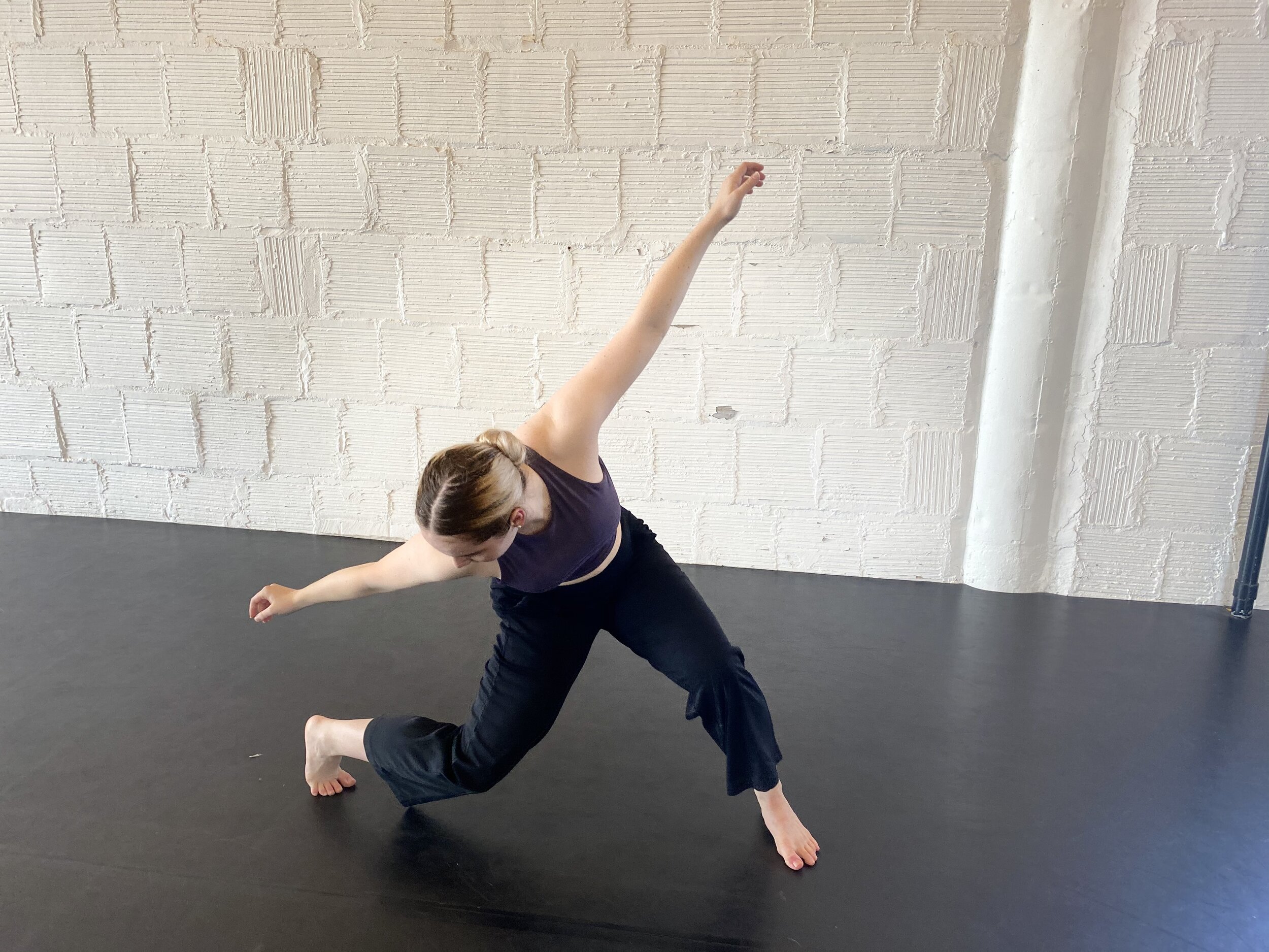 movement hair in bun white brick wall black Marley dance floor purple top Dance acting ballet jazz lyrical contemporary theater musical camp singing voice glee club Amber Keeley director Mpls classes twin cities workshops Spring Dance Theatre Academy