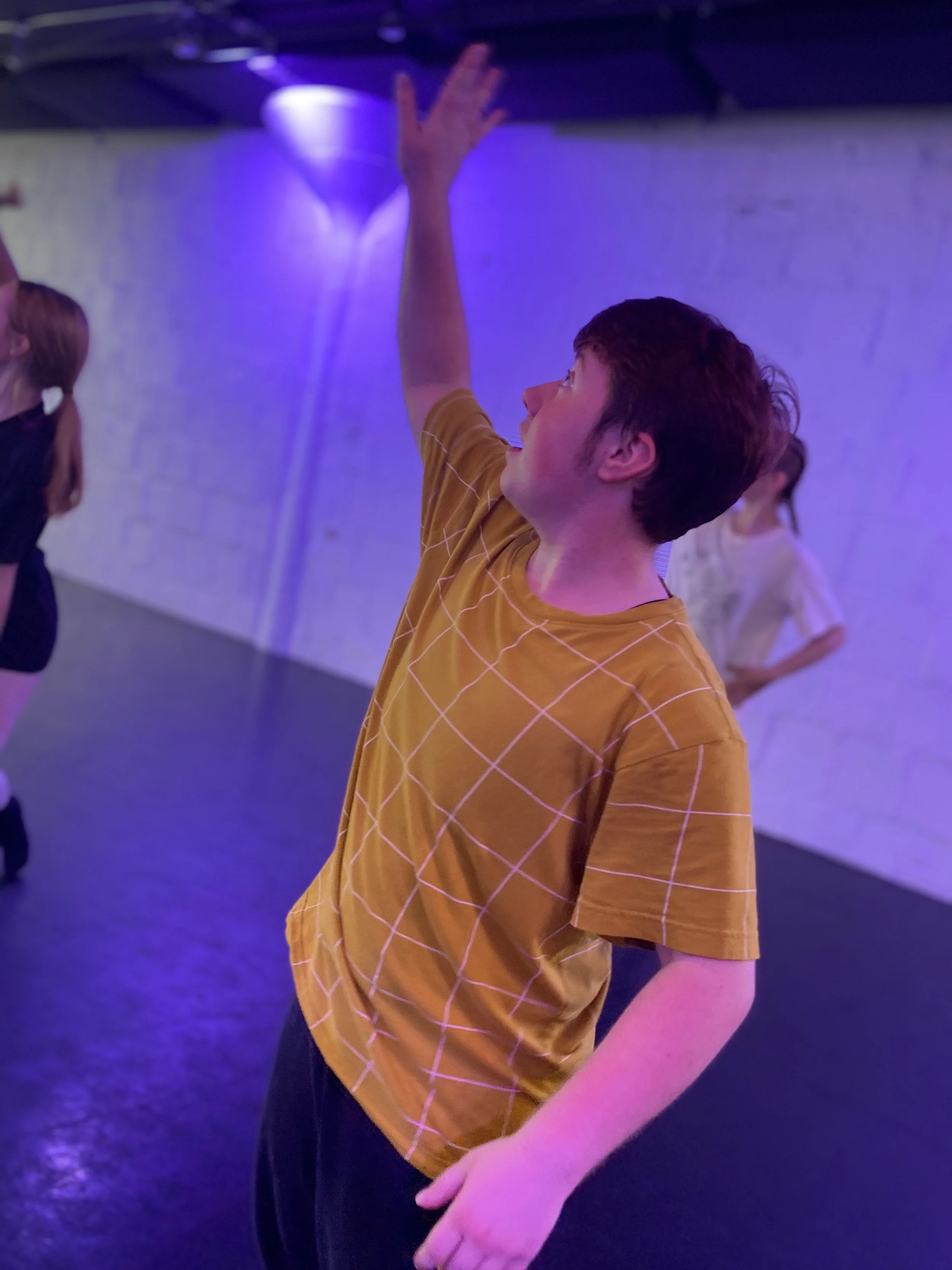 yellow shirt stripes black pants purple lights black floor white brick wall hand up  Dance dancer studio acting ballet jazz lyrical contemporary theater musical camp singing voice glee club Amber Keeley director Mpls classes twin cities workshops Spr