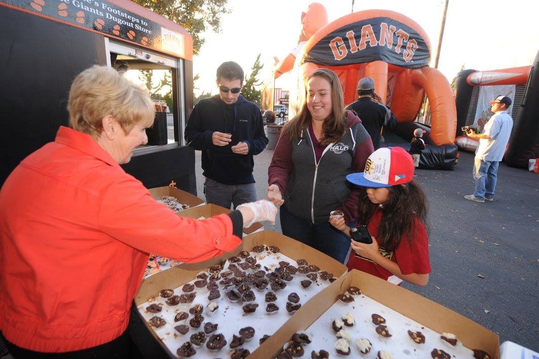 People grabbing heart-shaped brownie bites at Luv's Brownies 20 year anniversary at San Jose Giants Excite Ballpark (Copy)