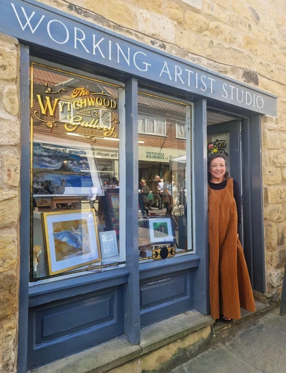 Business owner smiling at the front door of the artist's studio