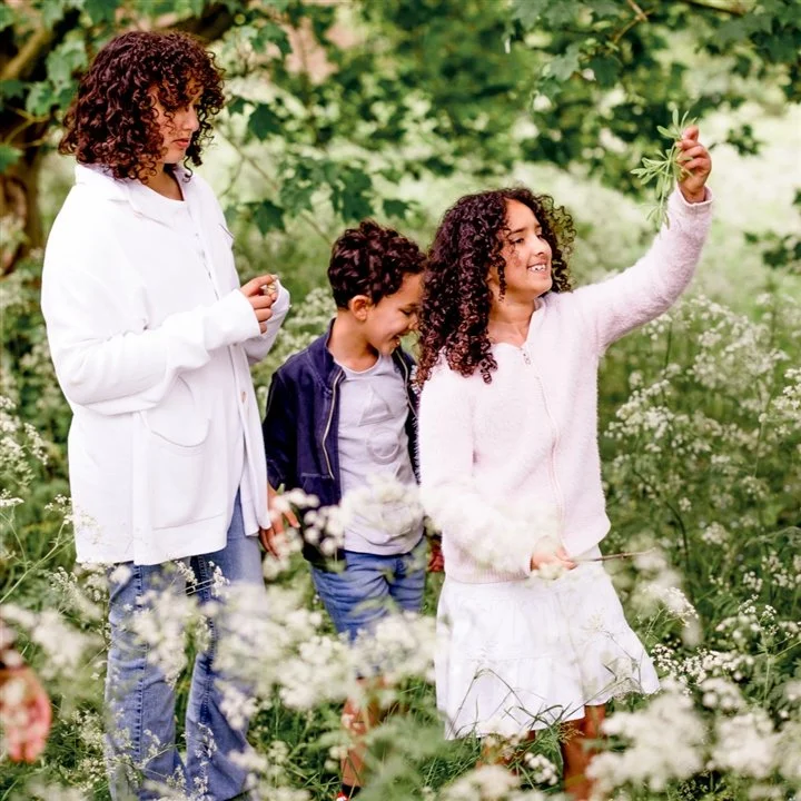 A family standing in a wooded area.