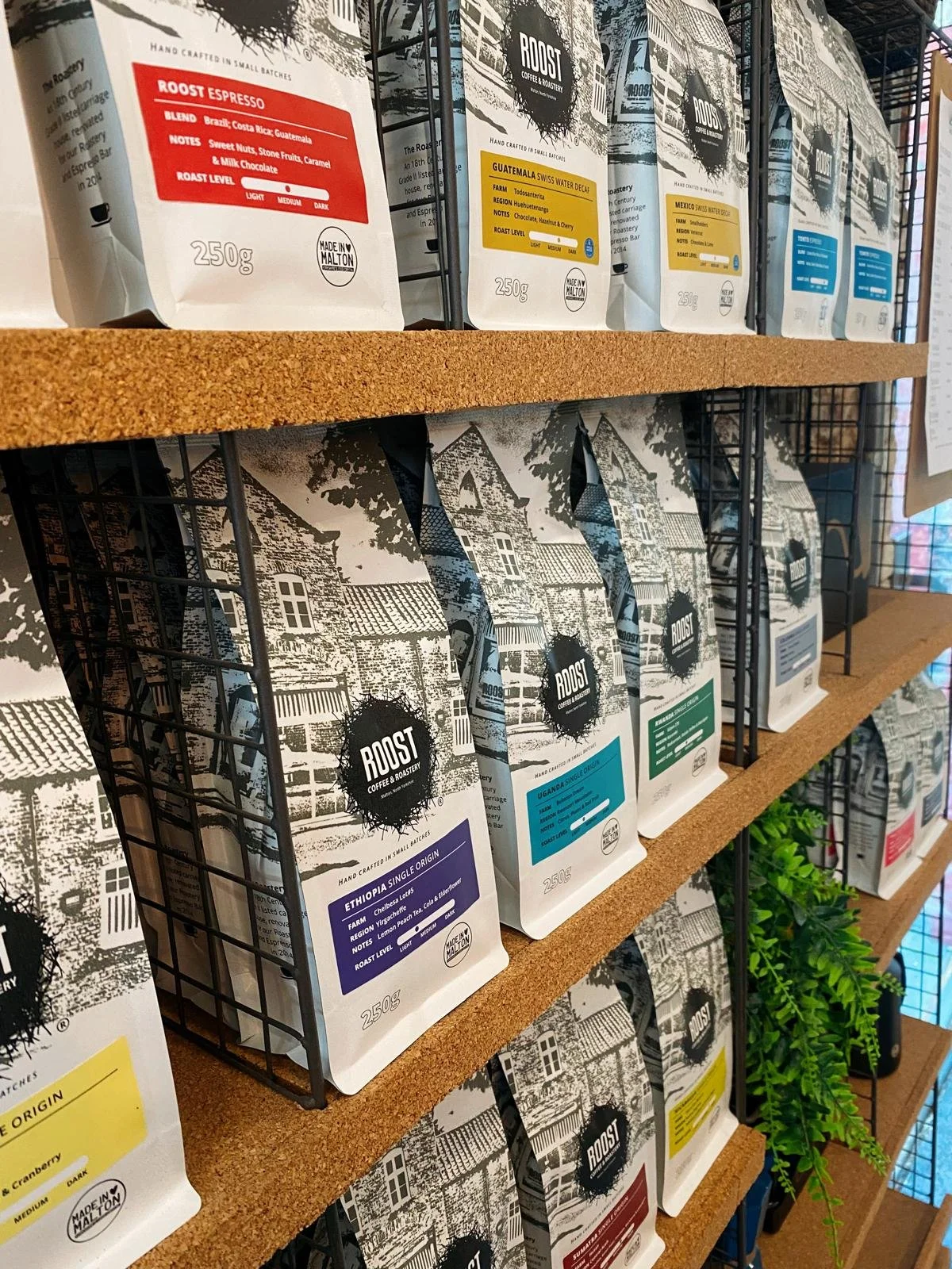 Bags of Roost Coffee with the brand design on the shelves in the espresso bar