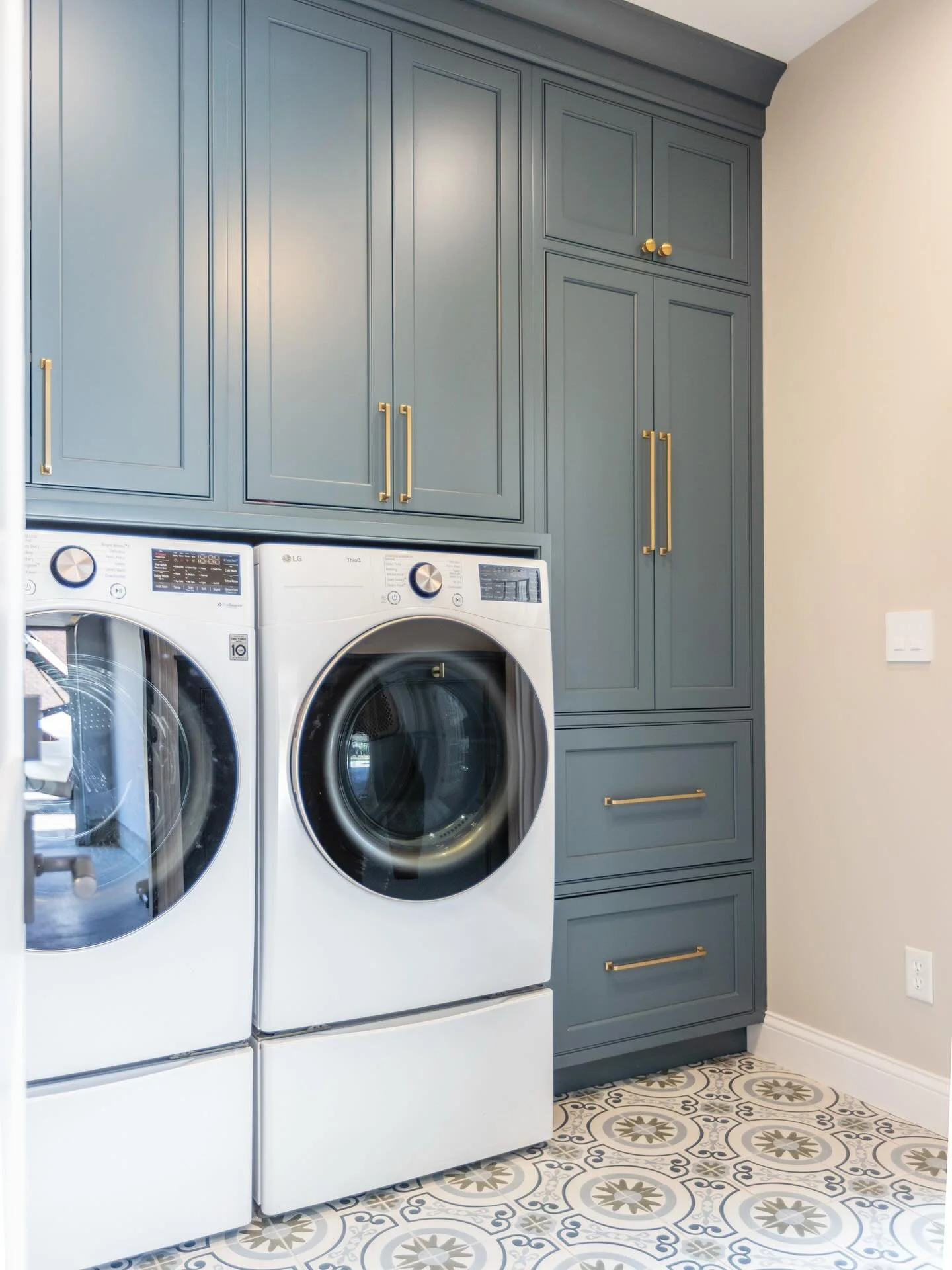 This laundry &amp; mudroom features bold blue cabinets, eye-catching patterned tile, and a mirrored barn door that cleverly conceals a hidden shoe closet. Function never looked so good! 💙🧺🧿 Swipe for before! 

Design: @nimbus9_interiors 
📸: @rvp_