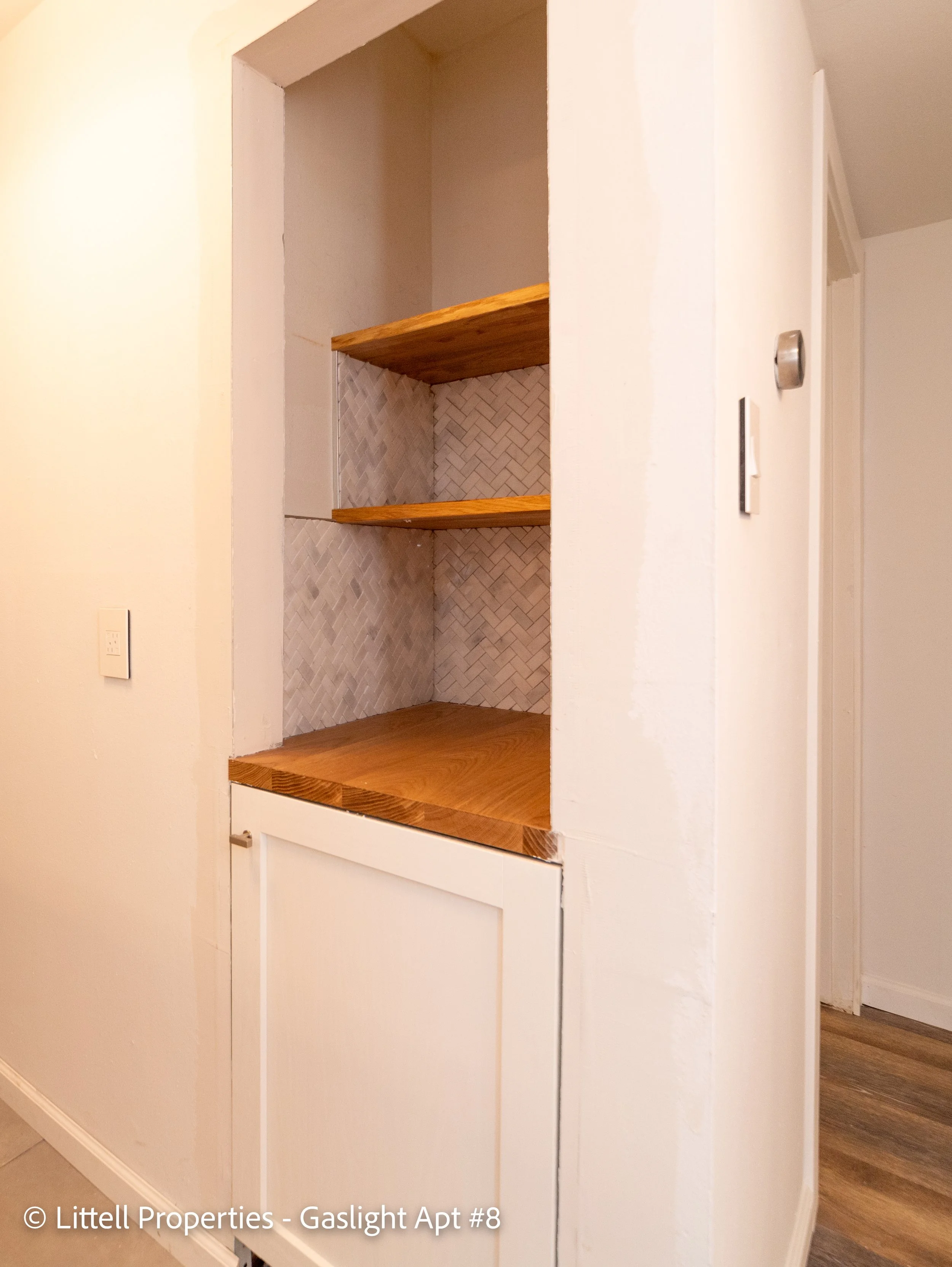  This built in storage nook is complete with marble backsplash  