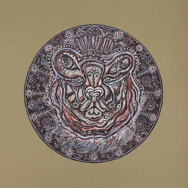 Decorative circular artwork of a stylized tiger's face with intricate patterns and floral designs, primarily in black, white, and reddish tones.