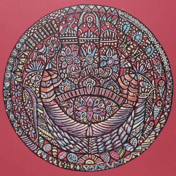 Colorful intricate mandala design featuring floral and abstract patterns on a pink background.